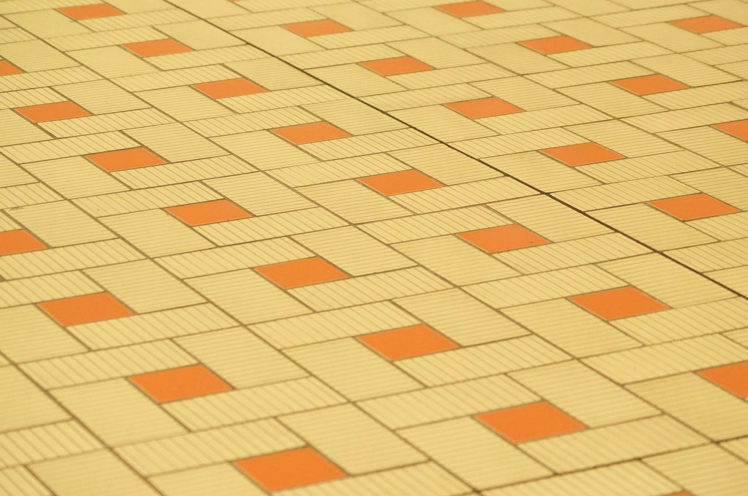 Carrelage de couleur crème avec des carrés orange disposés en motif