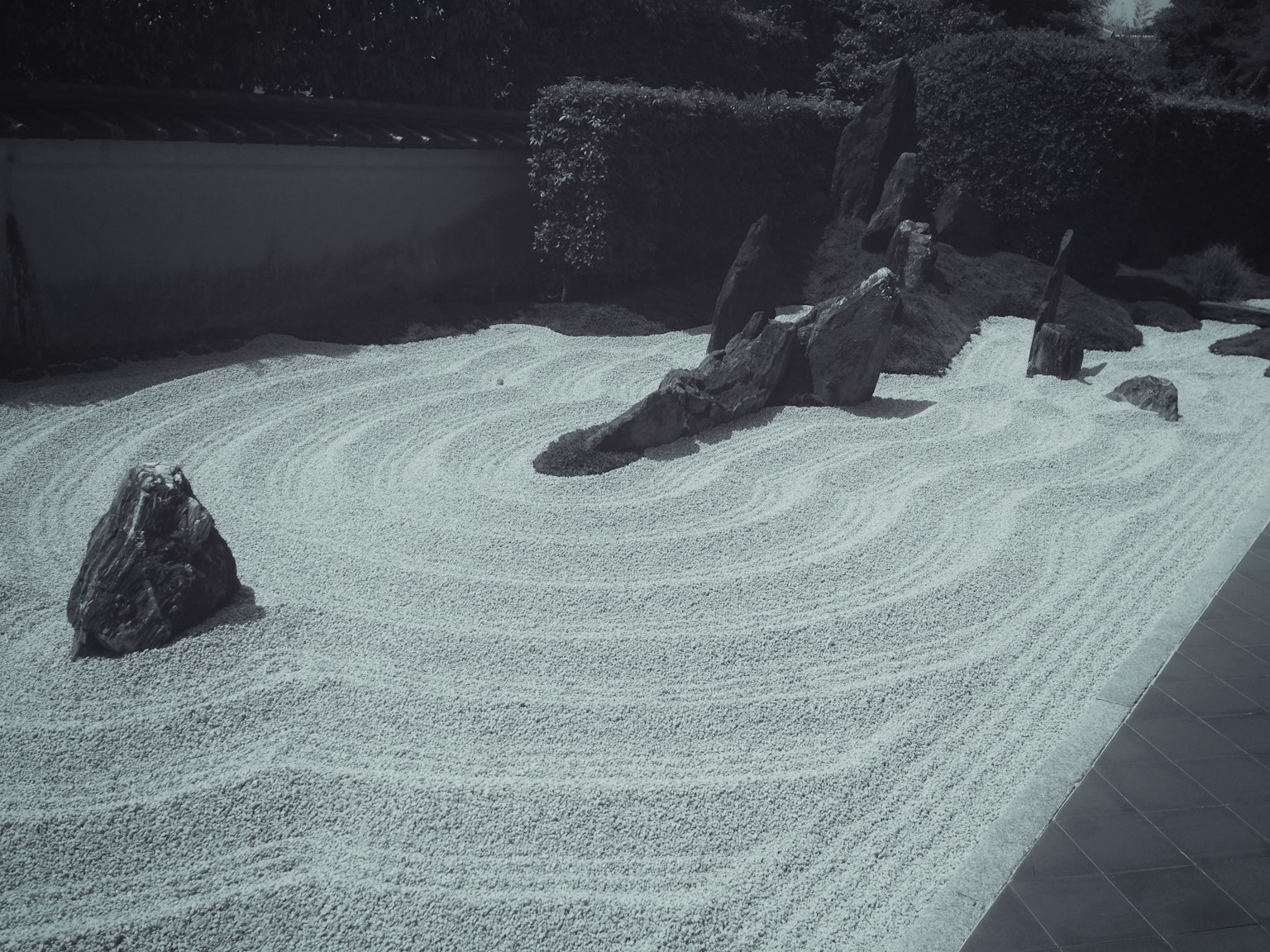 Zen garden with white sand and stones creating ripple patterns