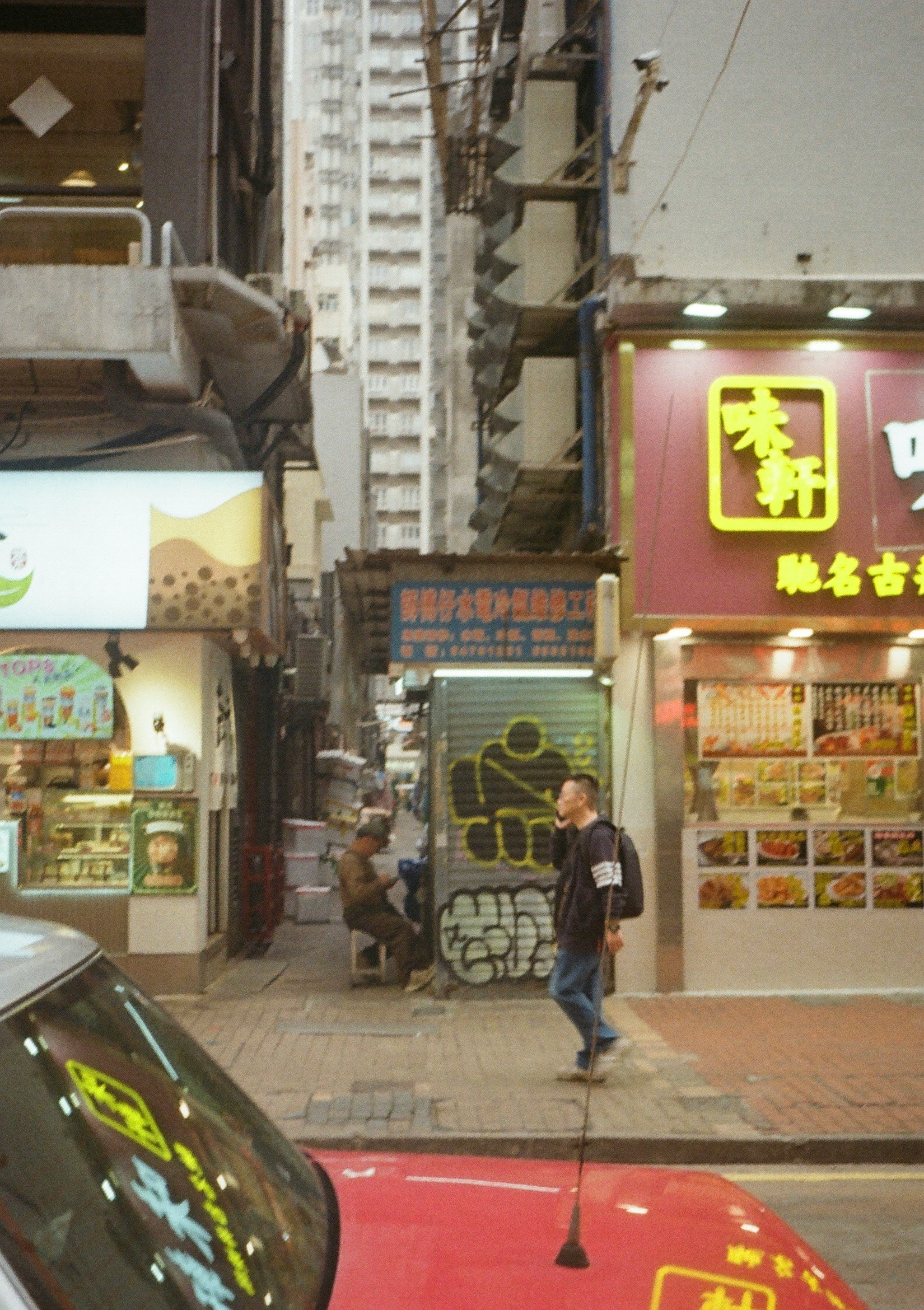 香港の街並みで人々が歩いている様子と店舗の看板
