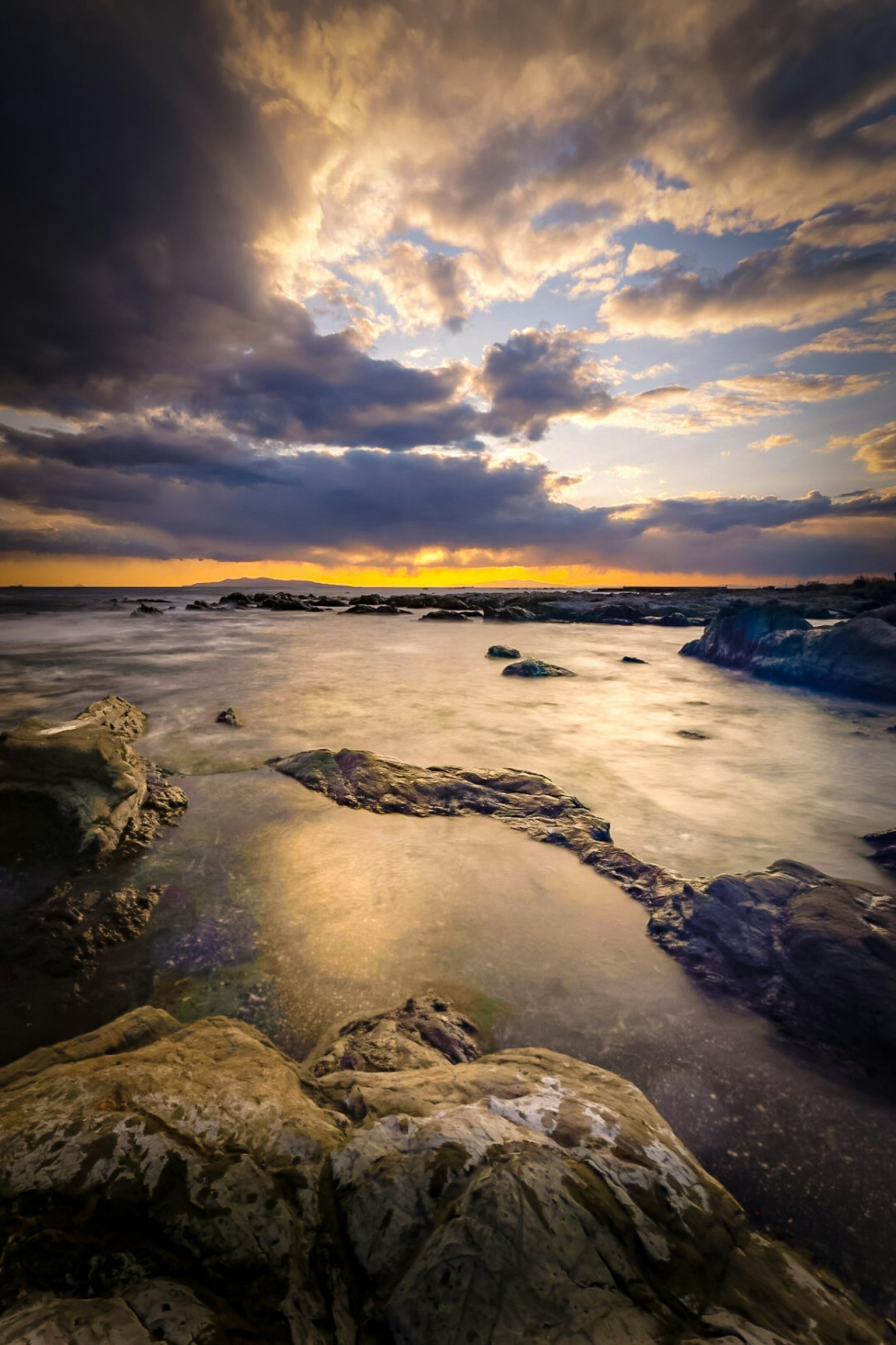 美丽的日落景观，海岸岩石和海浪