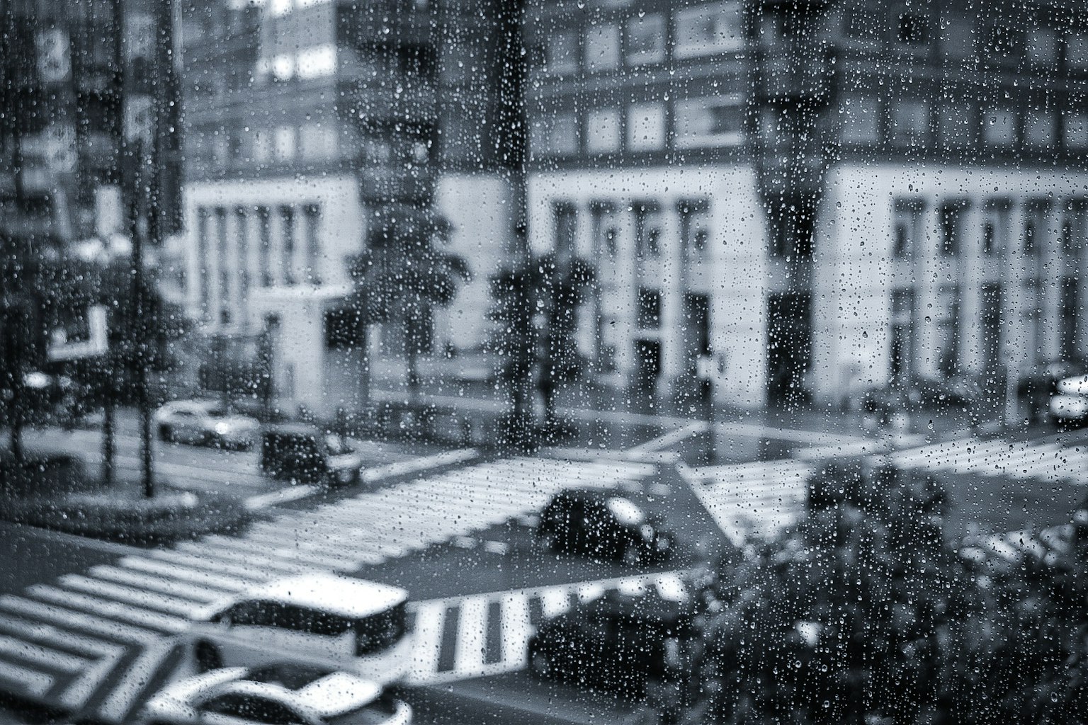 Urban scene in the rain blurred intersection and buildings