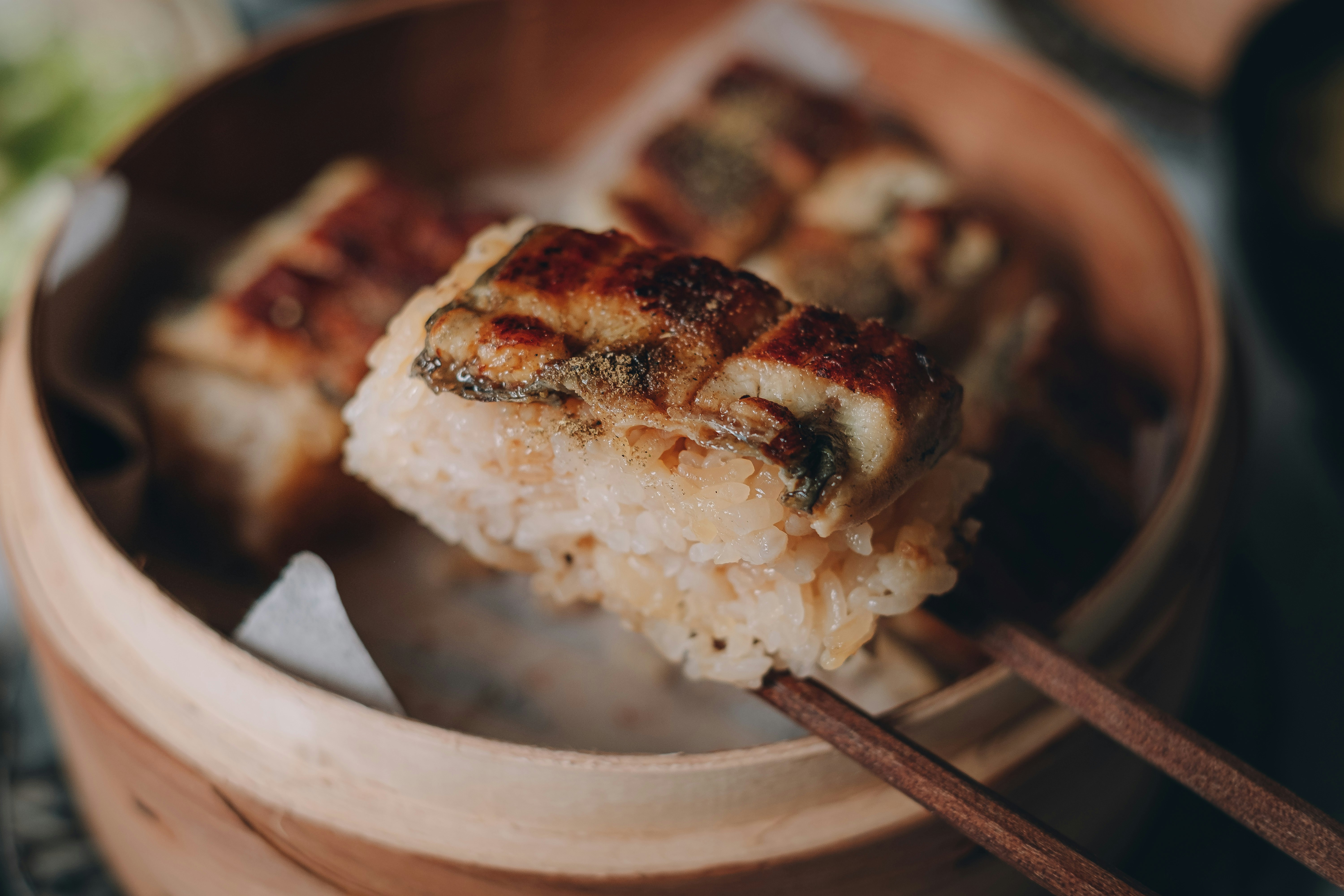 箸でつまむ焼きおにぎりのある食卓