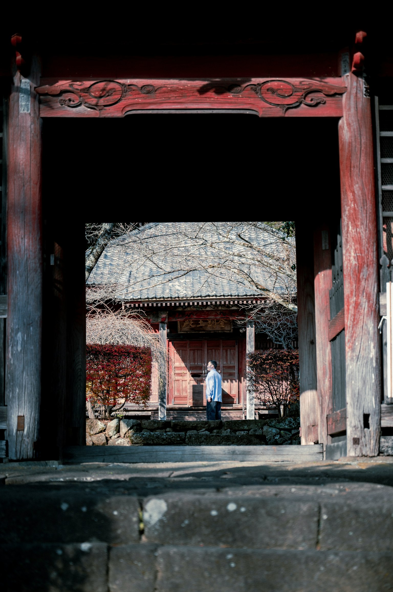赤い門を通り抜ける人物 古い建物の背景