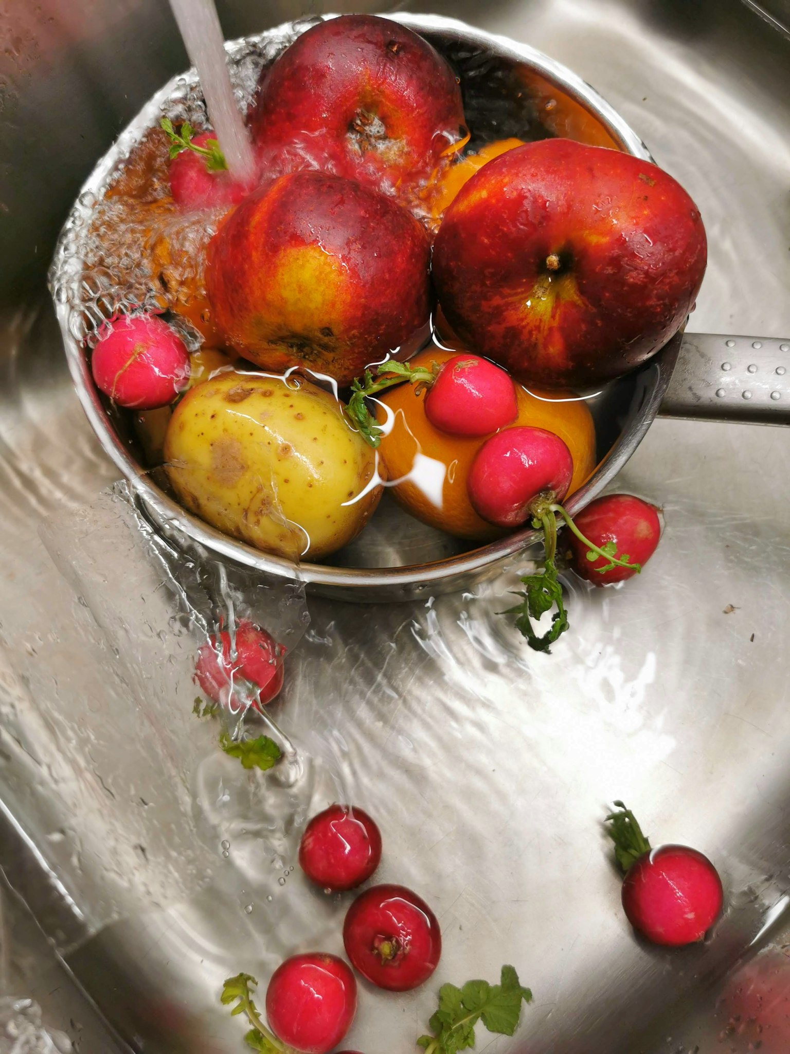 Un bol de pommes rouges et de radis lavés dans l'eau