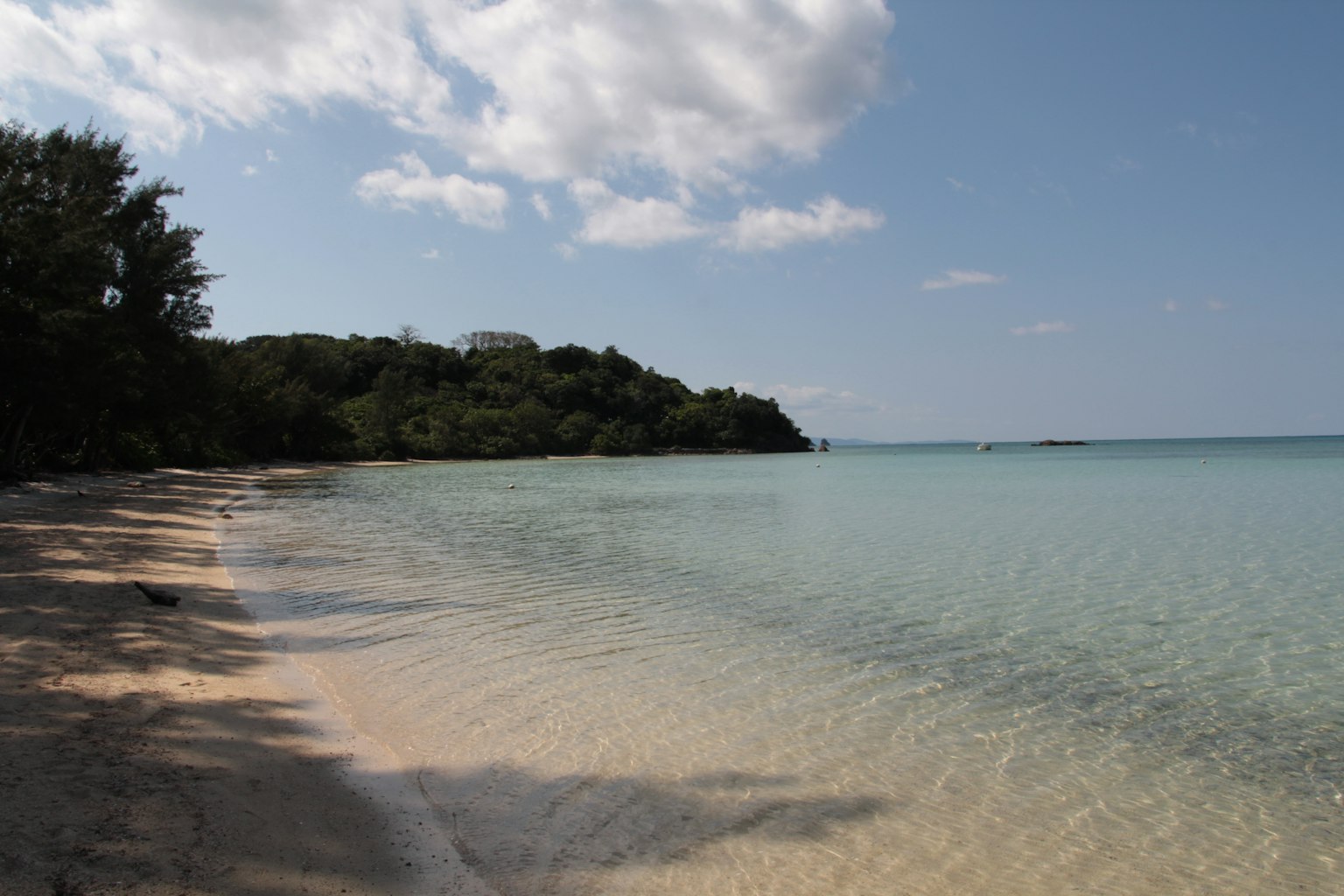 Pemandangan pantai yang tenang dengan air tenang dan pasir putih