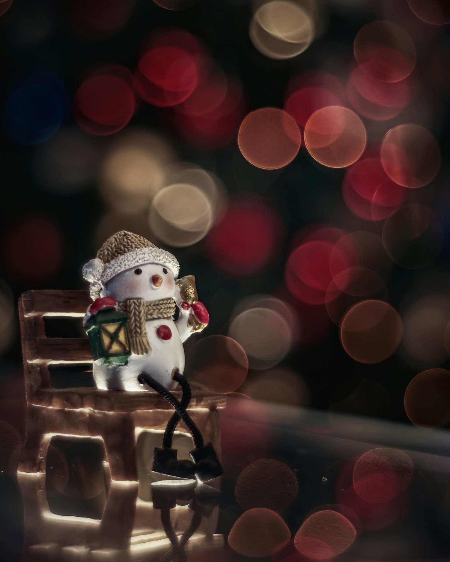 Una decoración de muñeco de nieve sentado en una silla con un fondo festivo