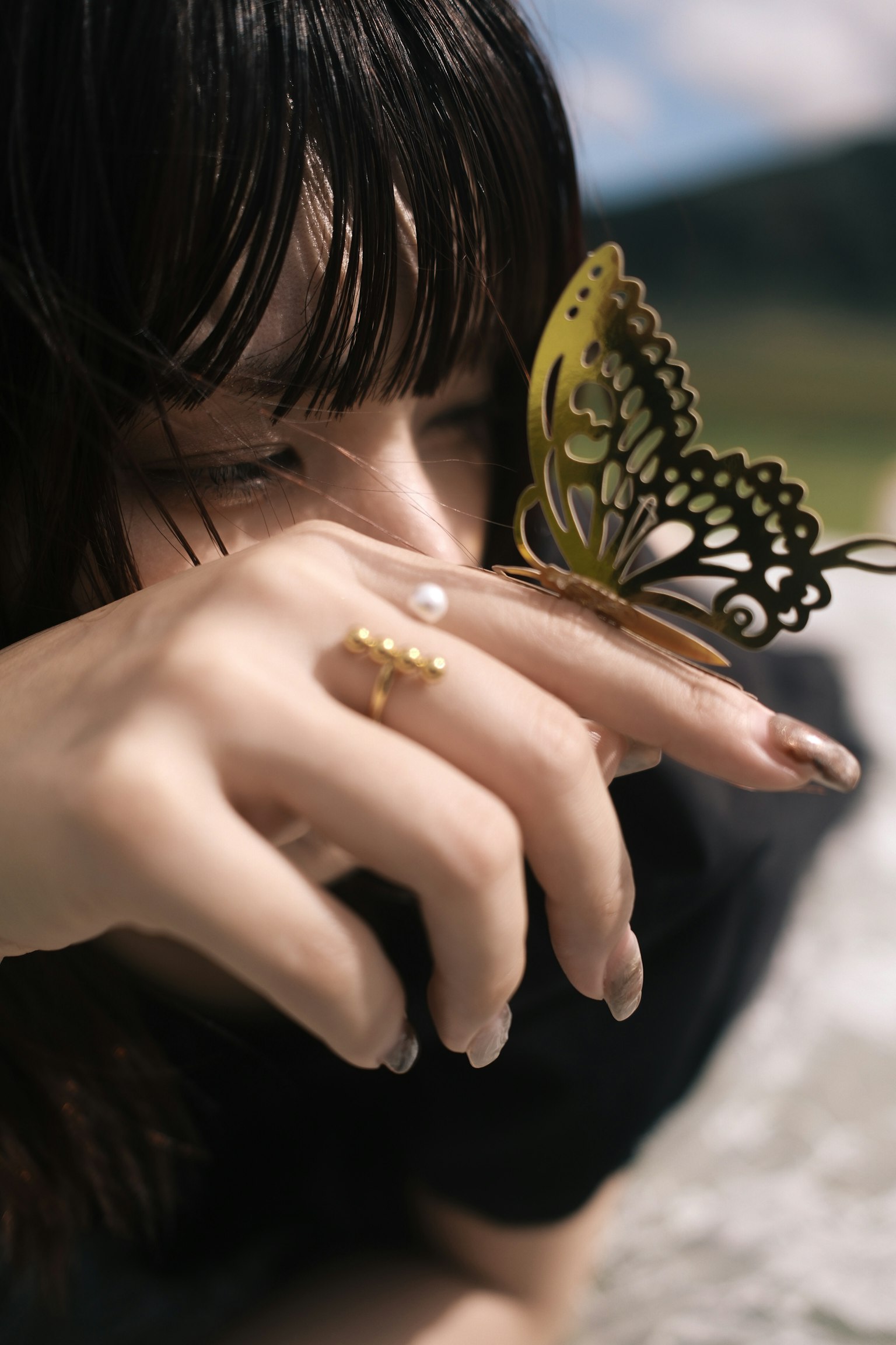 女性が手に蝶の装飾を持っている写真