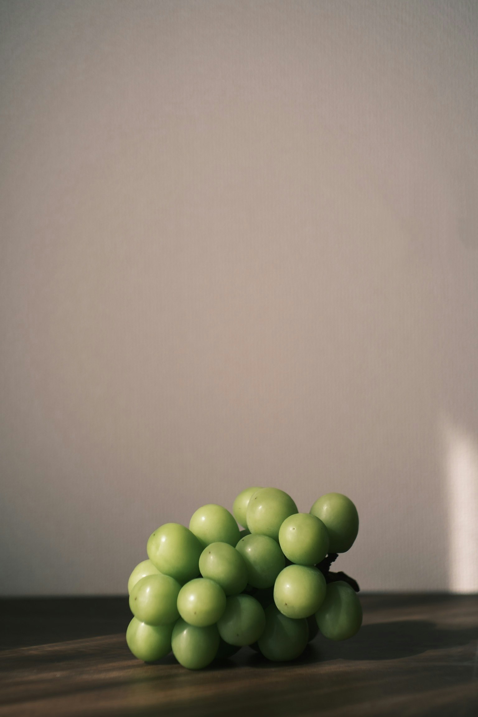 緑色のブドウの房がテーブルの上に置かれているシンプルな構図