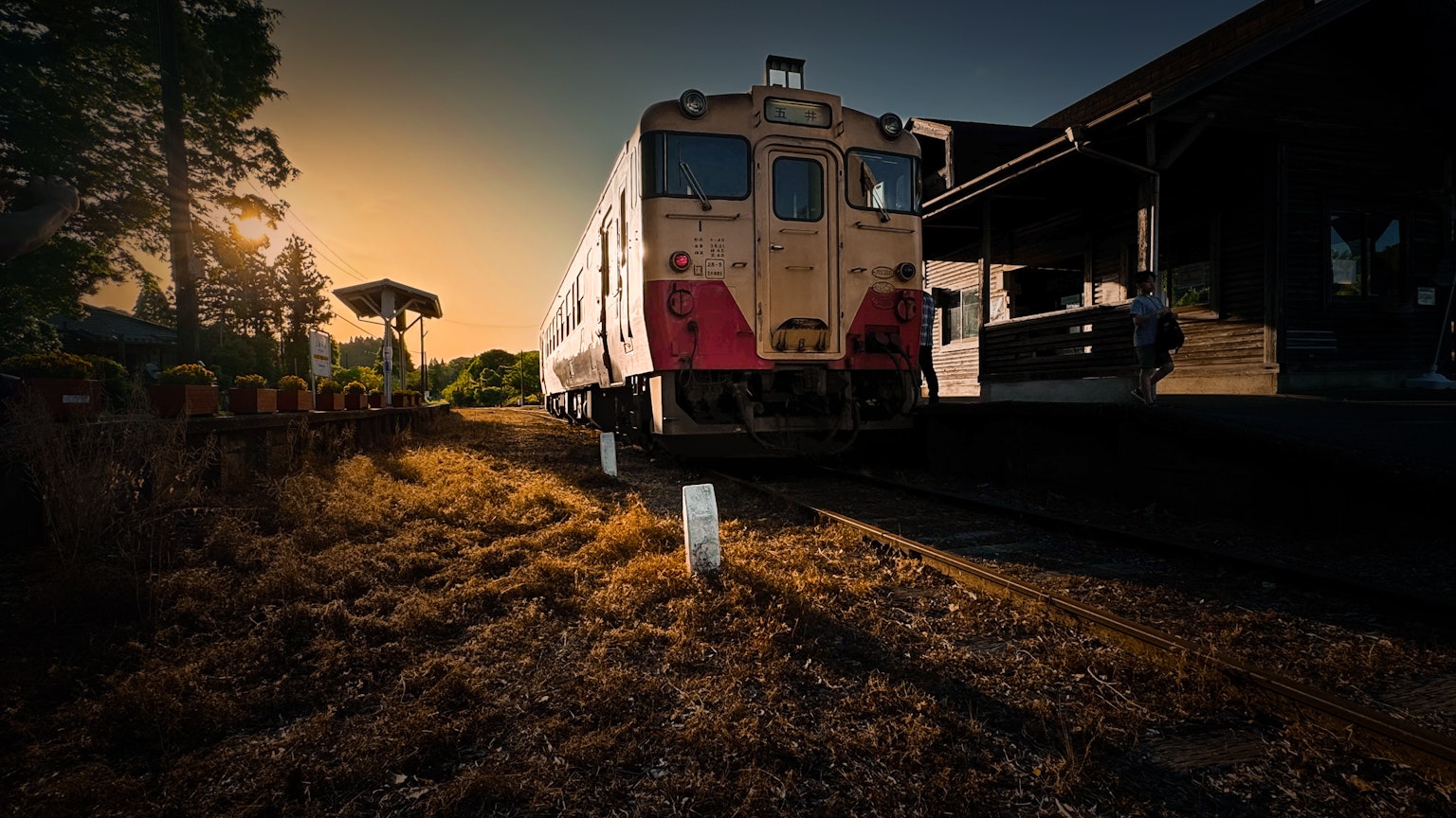Vecchio treno parcheggiato in una stazione al tramonto