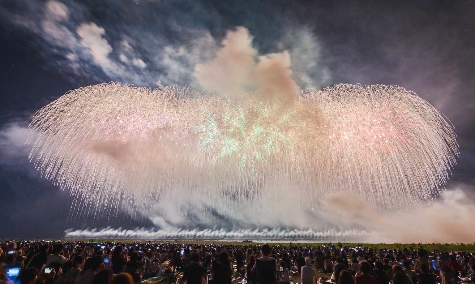 Grande spettacolo pirotecnico durante un festival con una grande folla che guarda lo spettacolo