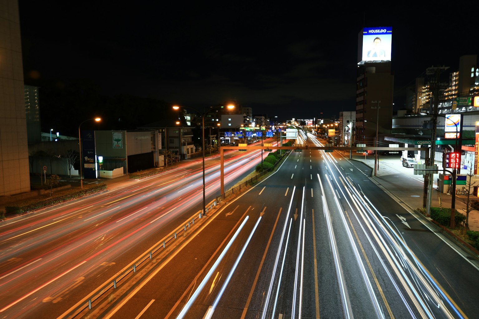 Traînées lumineuses de voitures sur une route de ville la nuit