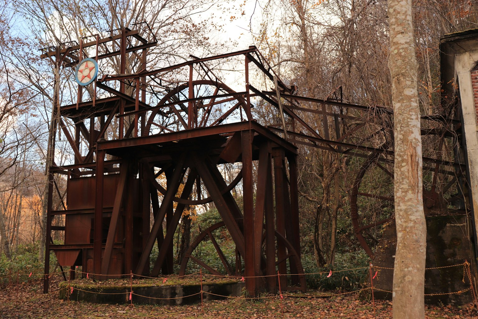 Estructura industrial oxidada rodeada de árboles