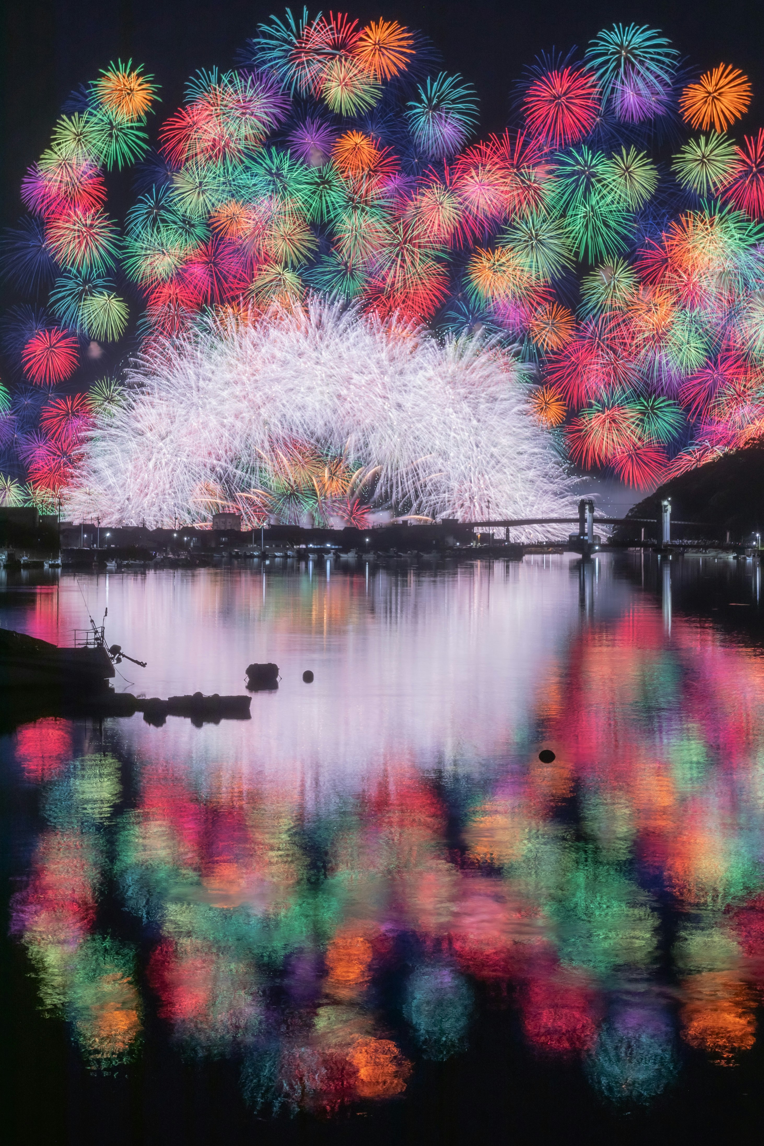 花火が水面に映る夜の湖畔の光景