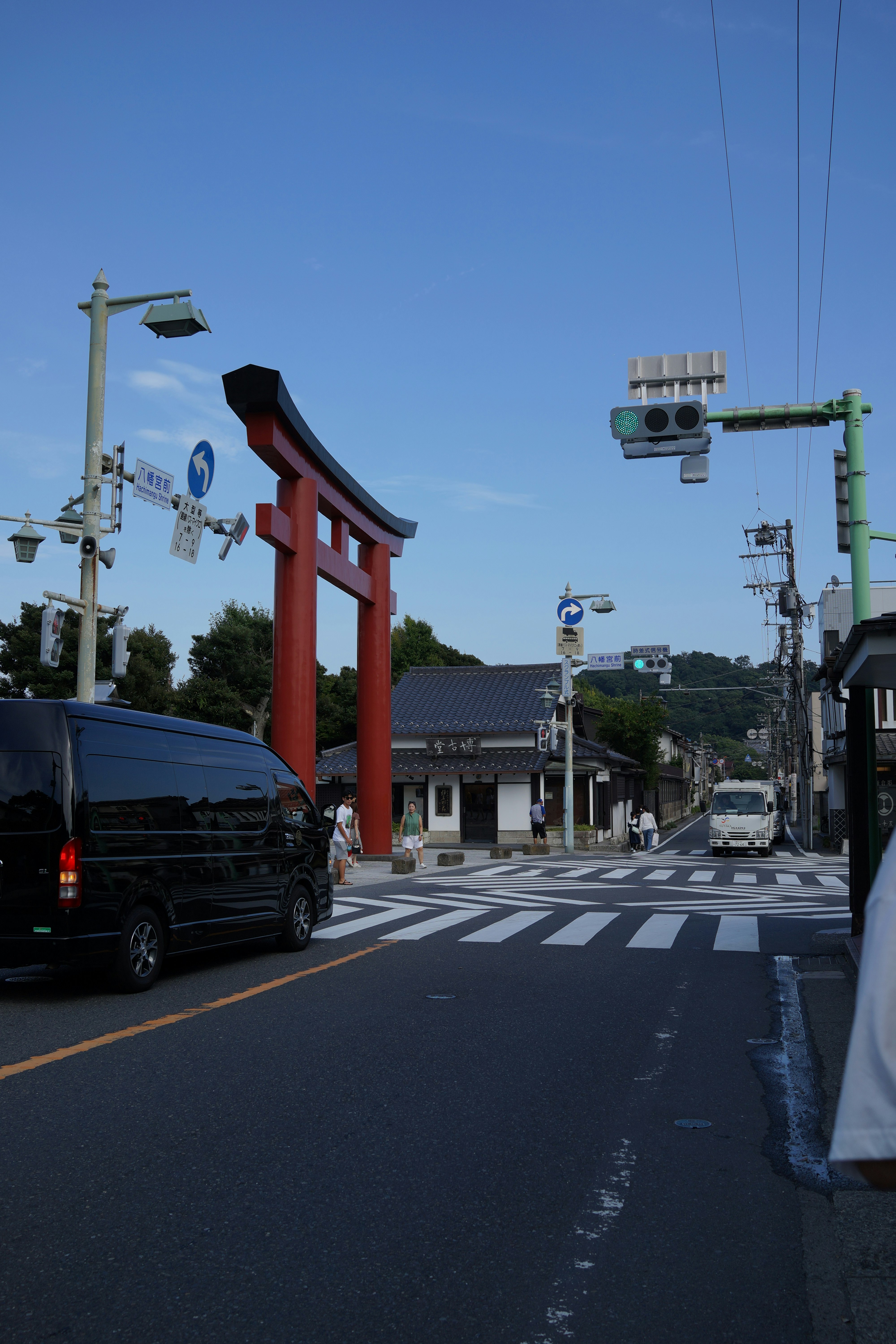 青空の下の鳥居と交差点の街並み
