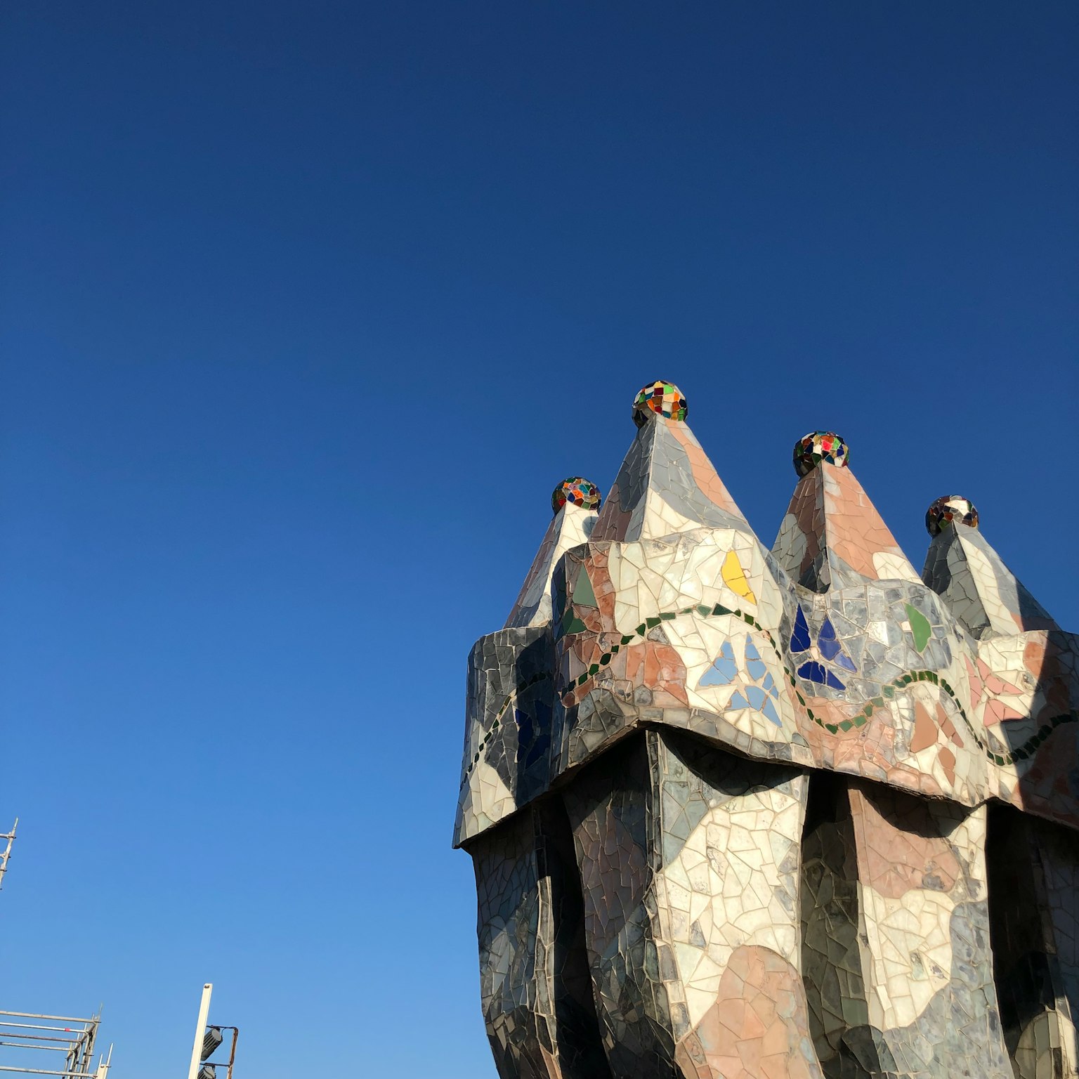Sommet de cheminée unique orné de mosaïques colorées sur fond de ciel bleu clair
