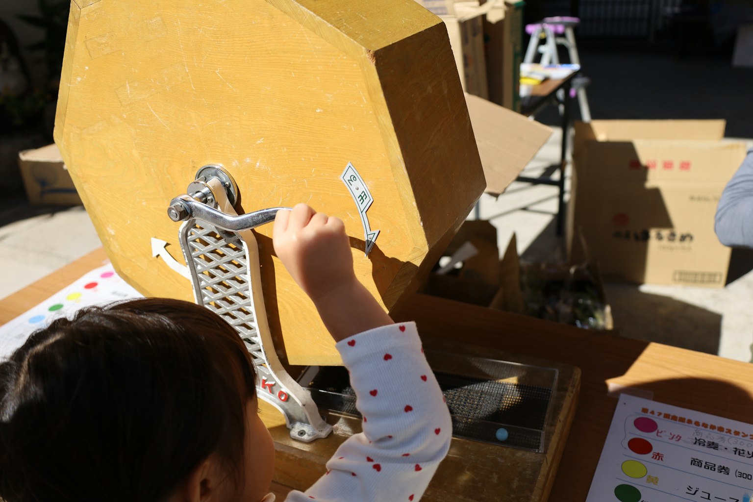 A child operating a rotating lottery machine