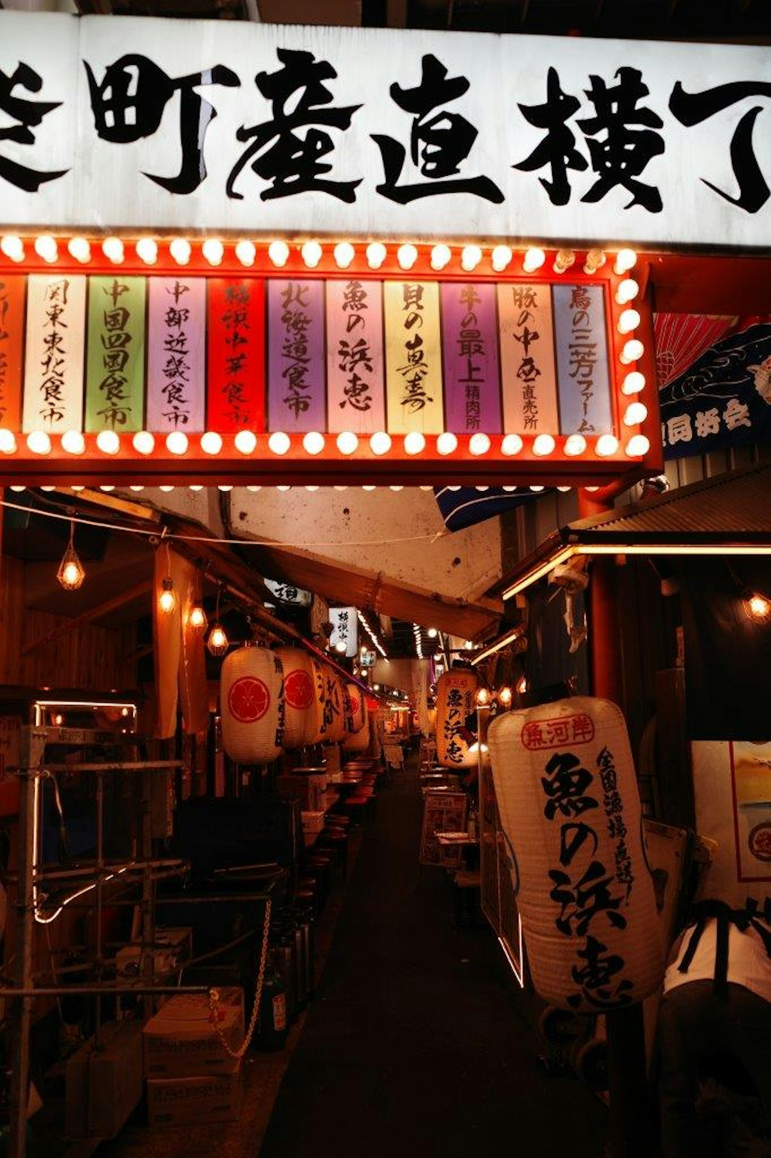 充滿活力的日本小巷入口，帶有霓虹燈標誌和五顏六色的燈籠