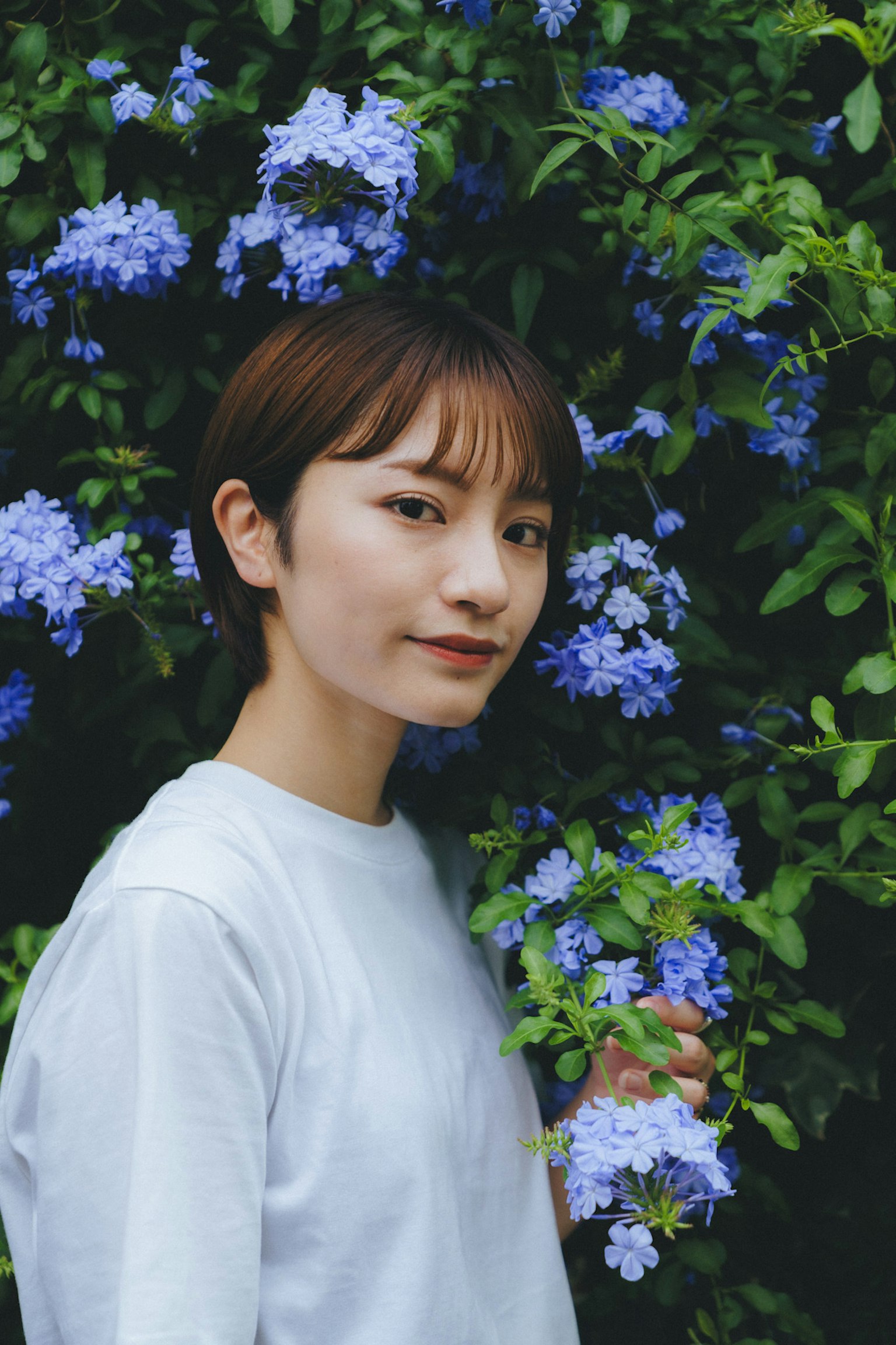 Porträt einer Frau umgeben von blauen Blumen