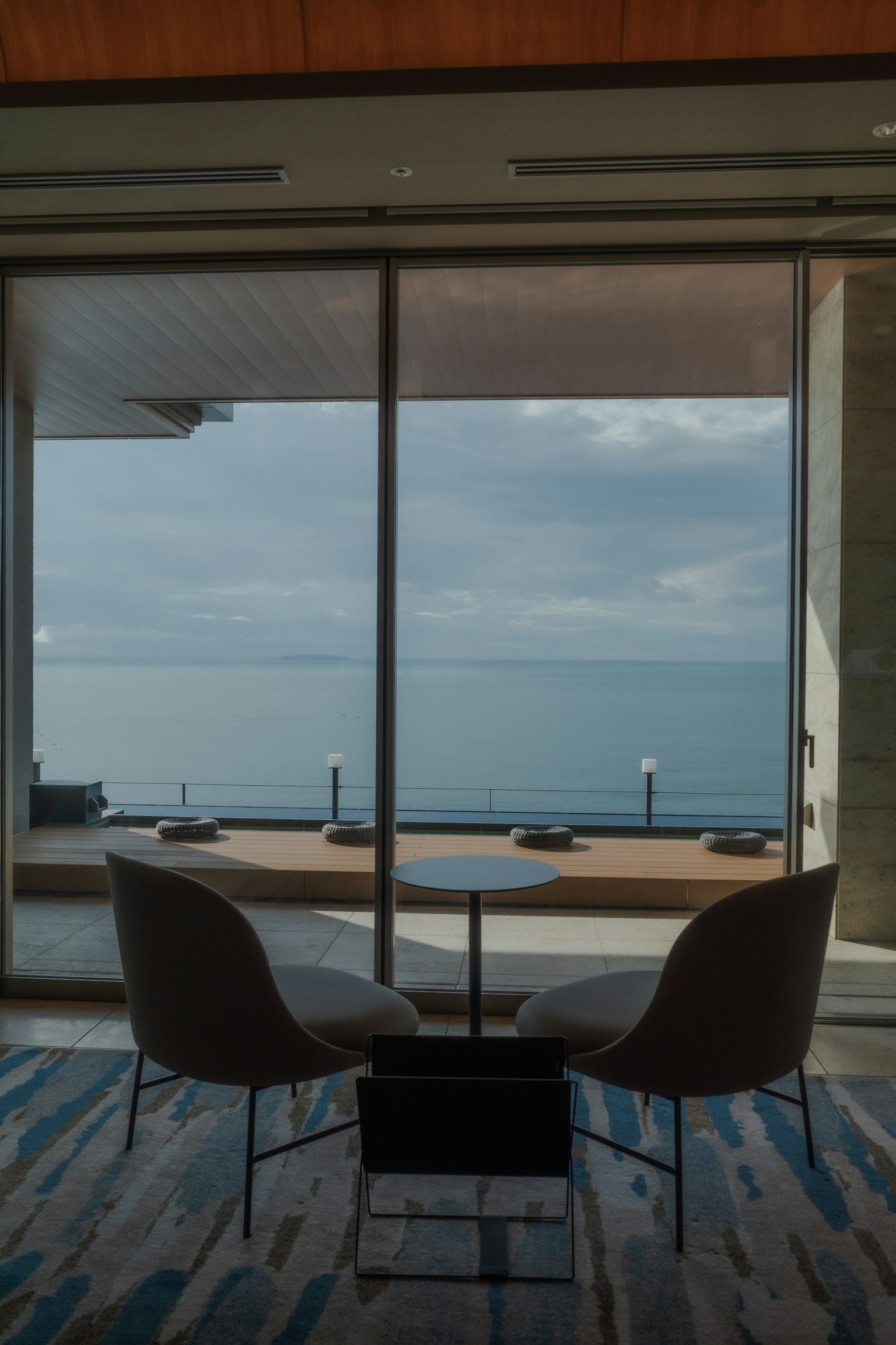 Interior moderno con sillas y mesa con vista al mar