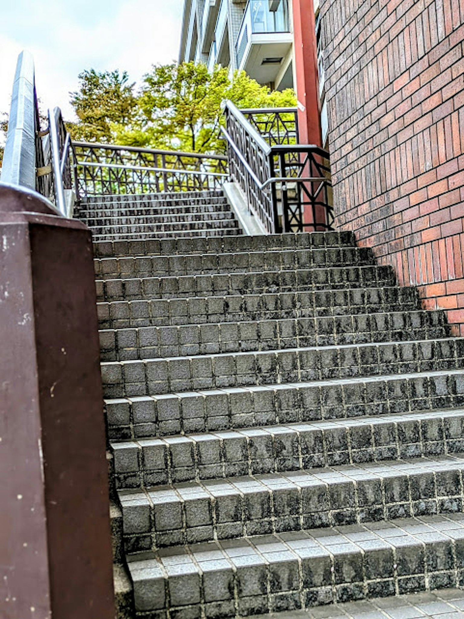 Treppenaufgang mit Ziegelmauer und Grünflächen