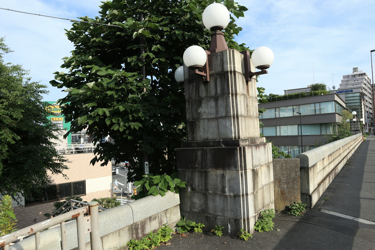 Pilier de pont en béton avec lampadaires et verdure