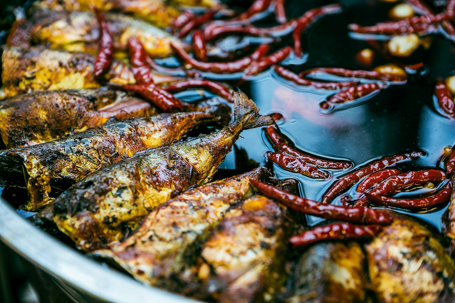 Ikan bakar disusun dengan cabai merah kering dalam saus gelap