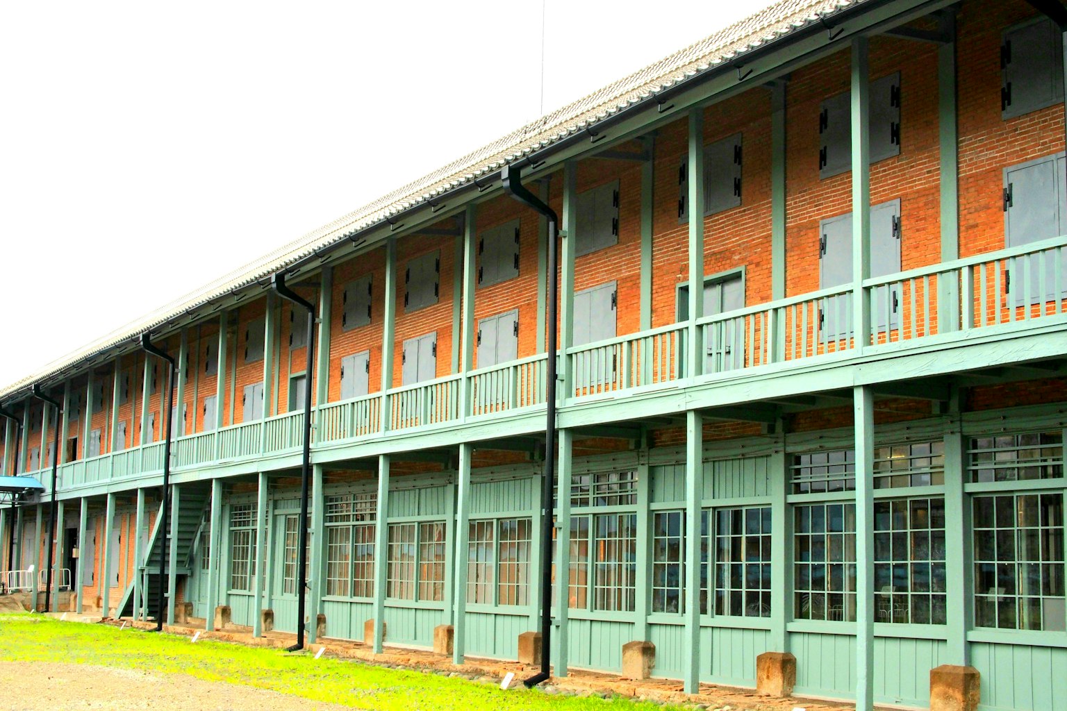 Ancien bâtiment en briques avec balcons bleus et fenêtres en bois