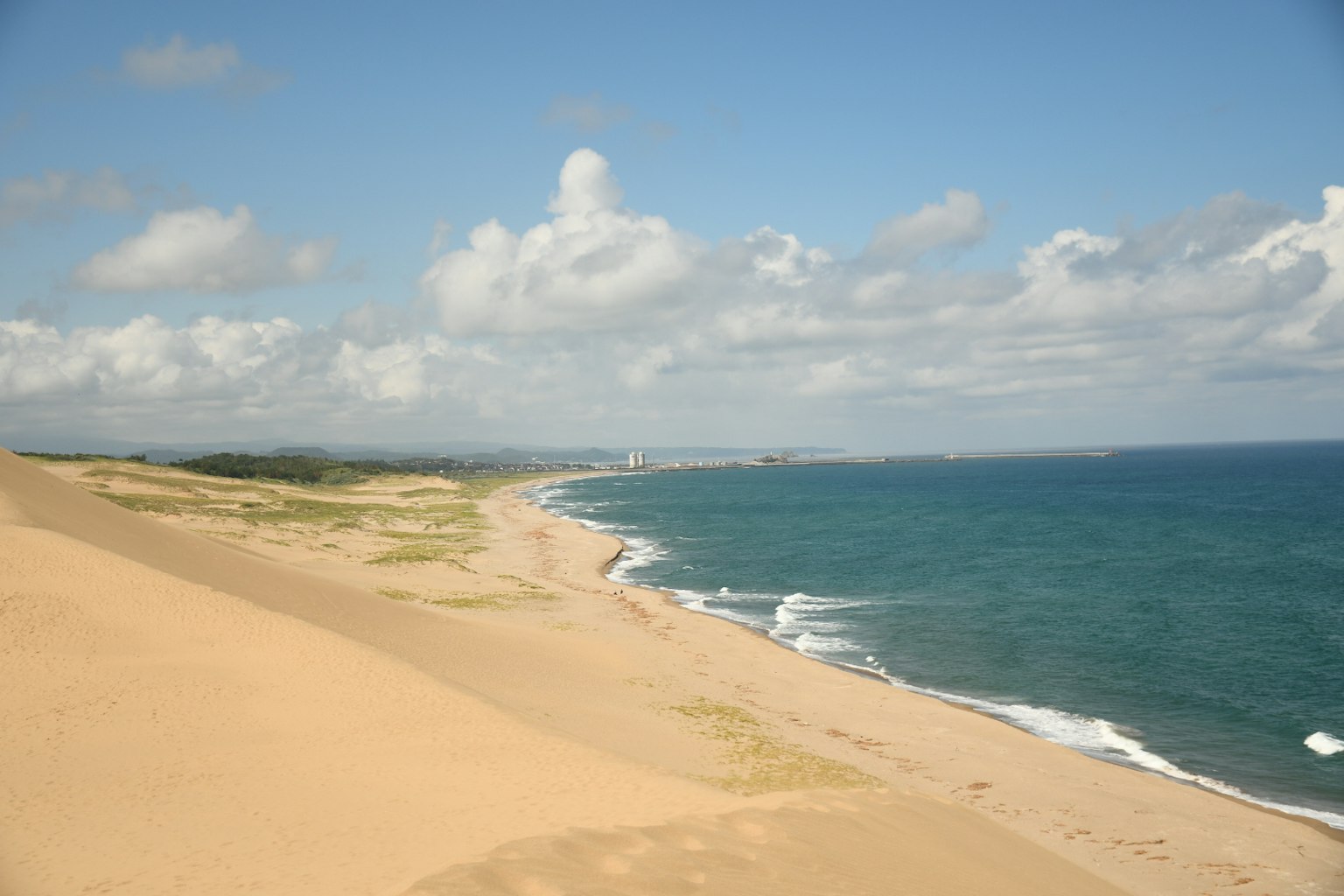 ทิวทัศน์ชายหาดที่สวยงามพร้อมมหาสมุทรสีฟ้าและชายฝั่งทราย