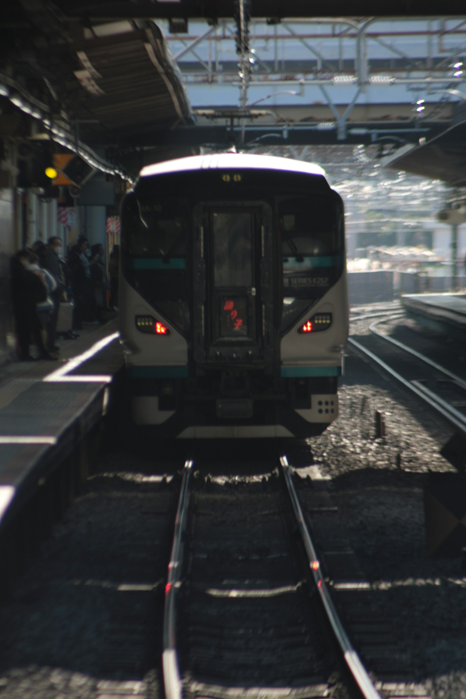 Tampilan depan kereta yang tiba di stasiun dengan rel yang terlihat