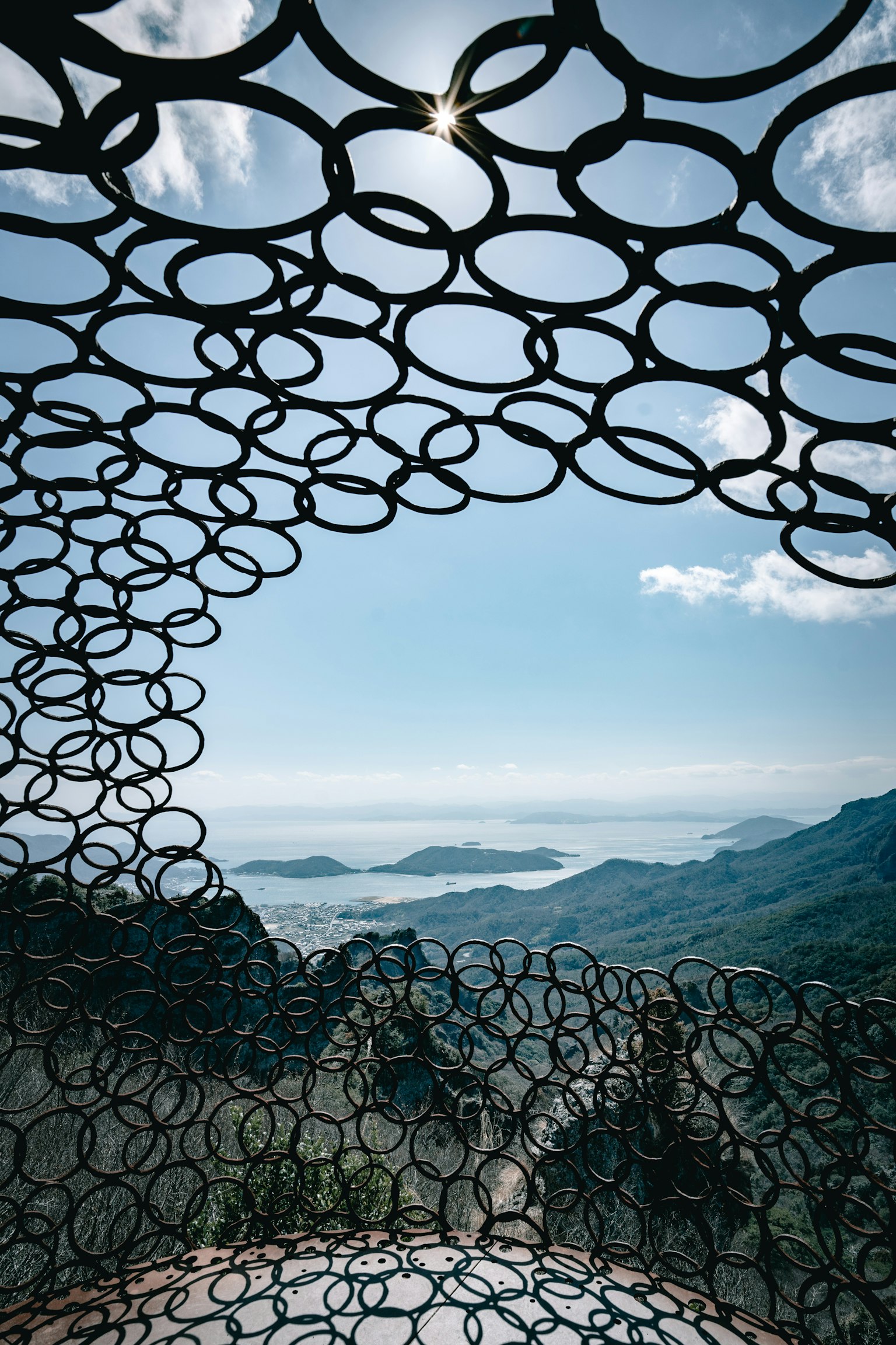 View from inside a circular structure overlooking mountains and sea