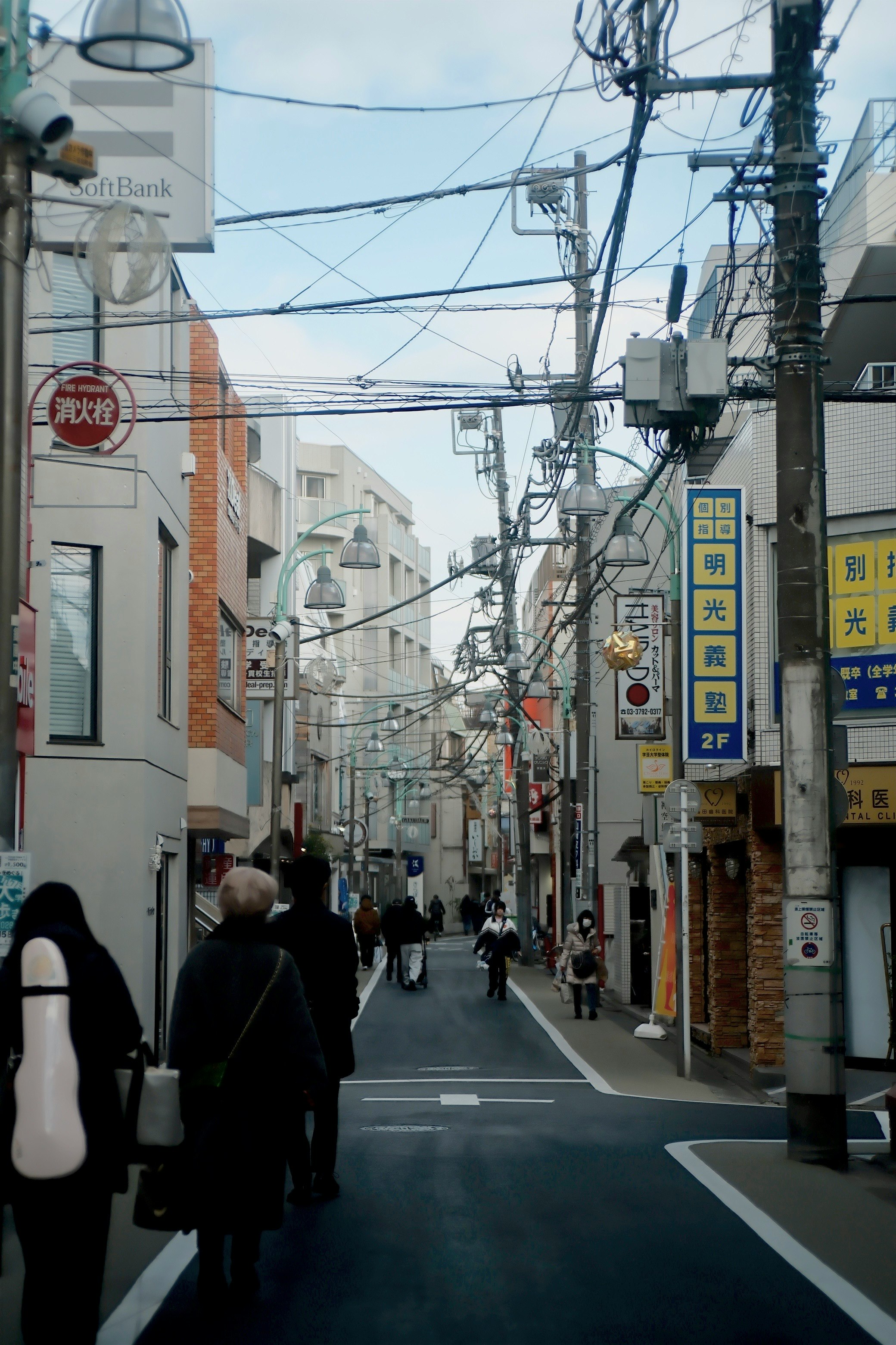 路地に並ぶ電線と看板のある商店街の通り