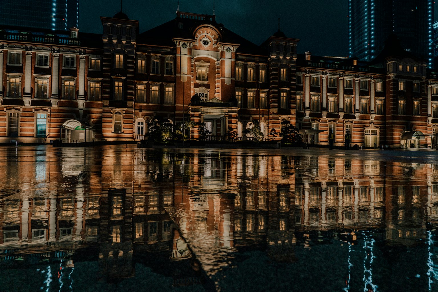 Hermosa vista nocturna de la estación de Tokio reflejada en el agua