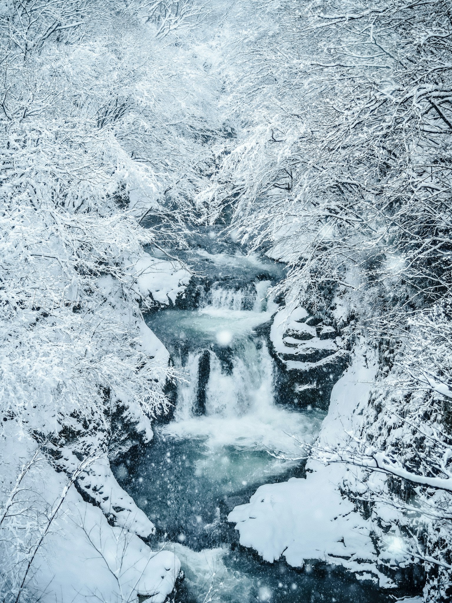 Verschneite Bachlandschaft mit weißem Schnee und ruhigem Wasserfluss