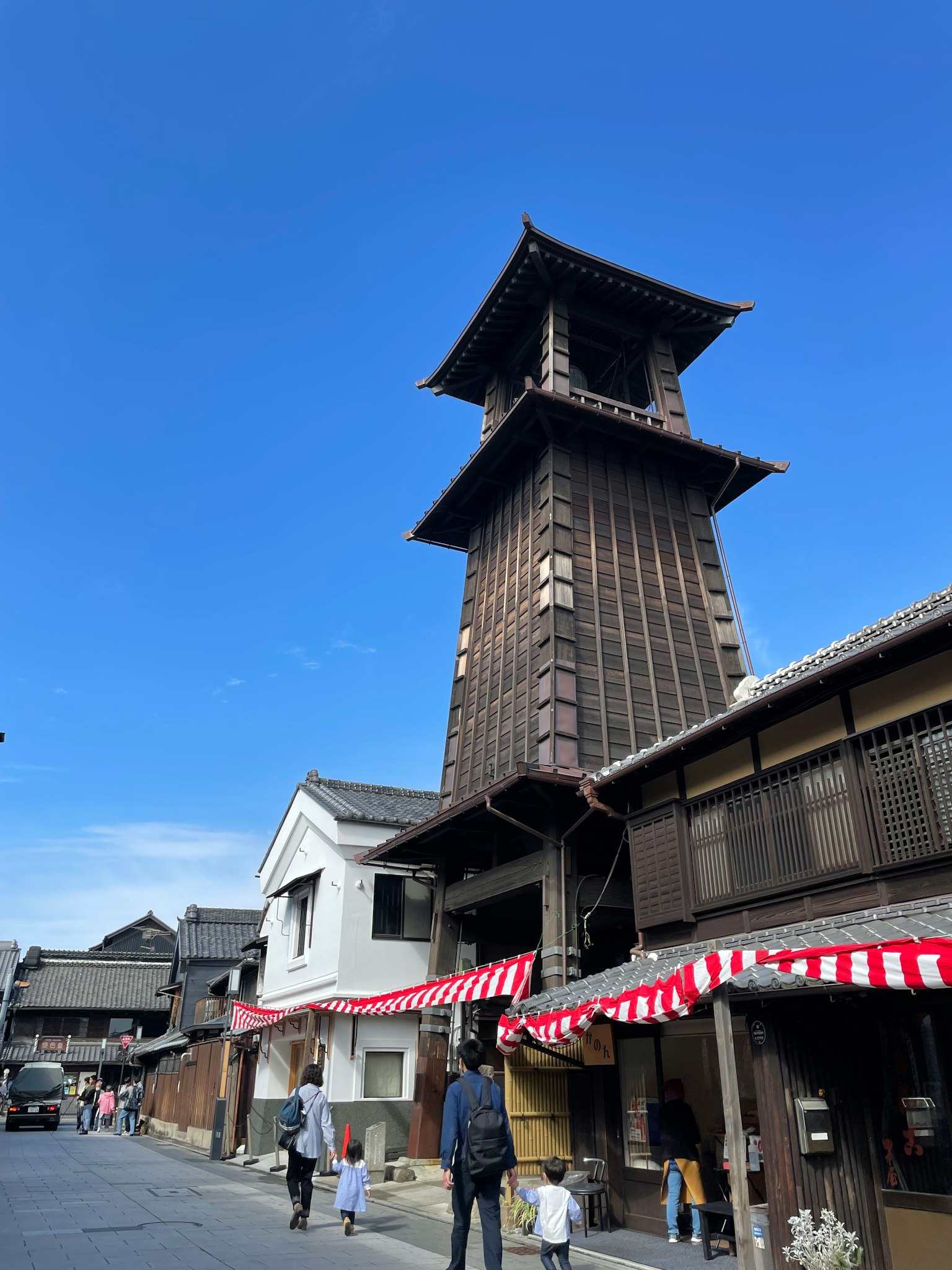 Arquitectura de madera tradicional con una alta torre del reloj contra un cielo azul