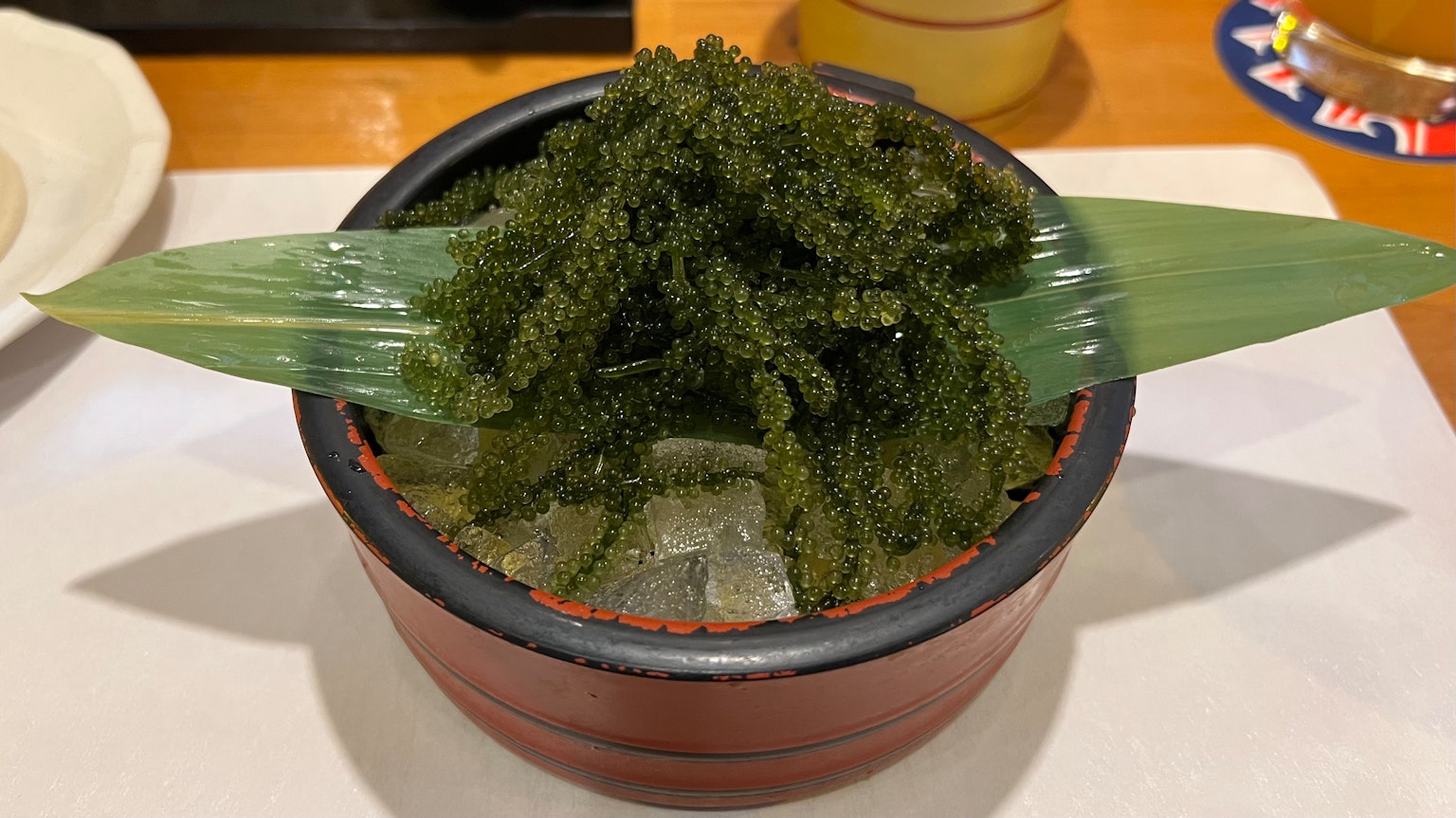 一个装满绿色海藻并用竹叶装饰的碗