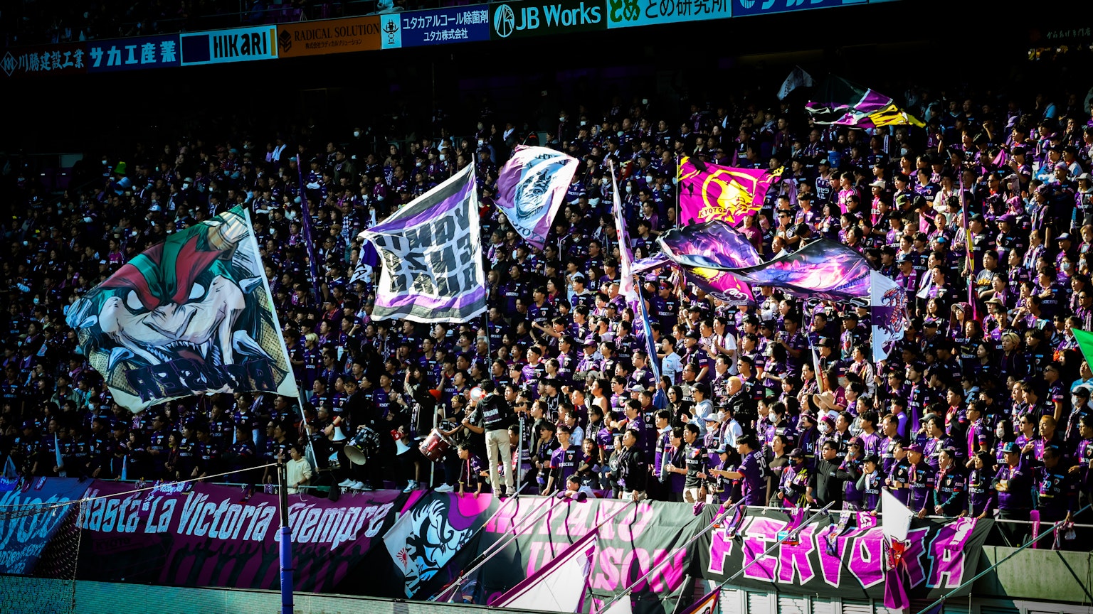 Passionate soccer fans waving flags during a match