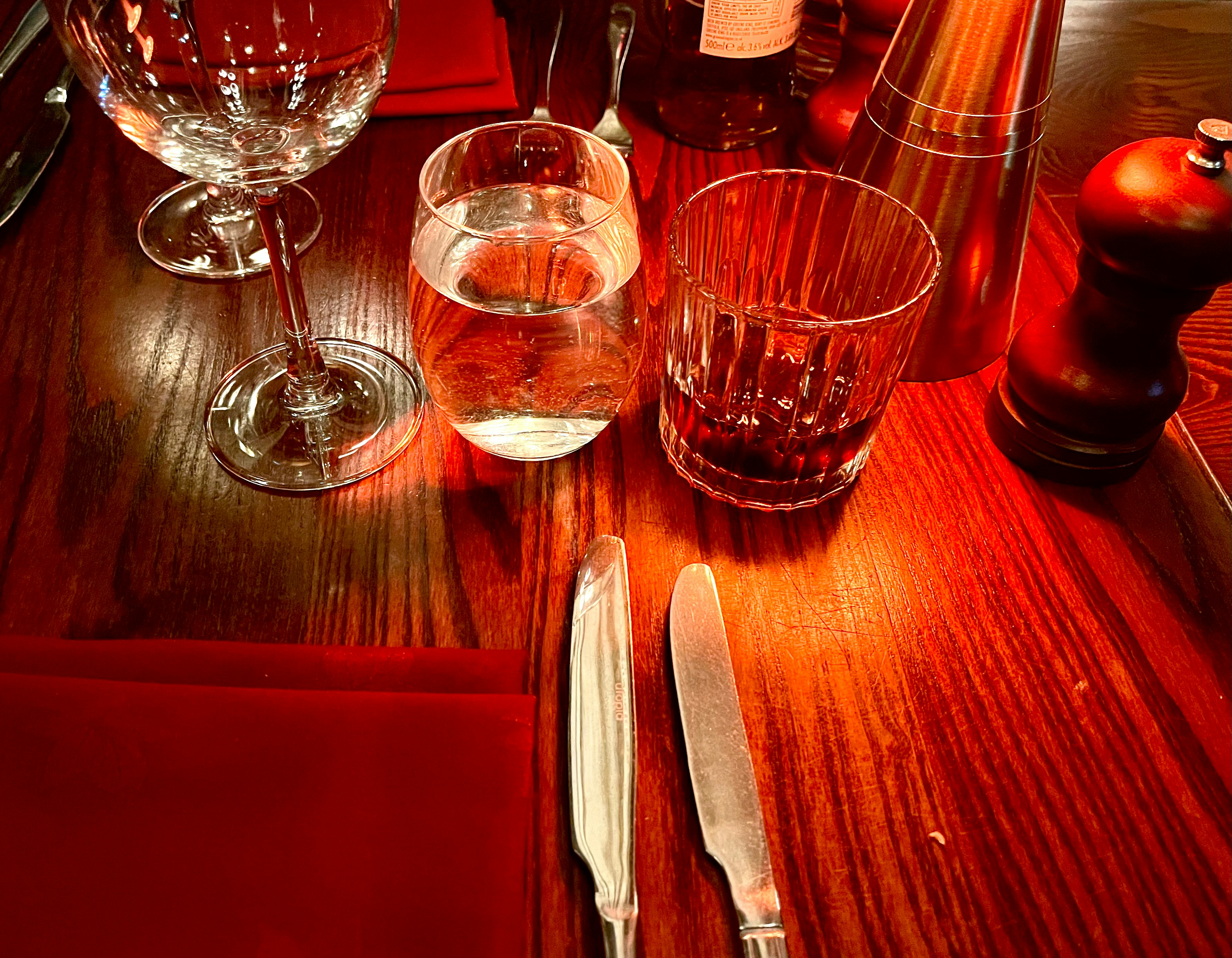 Wine glasses and cutlery on a red table setting