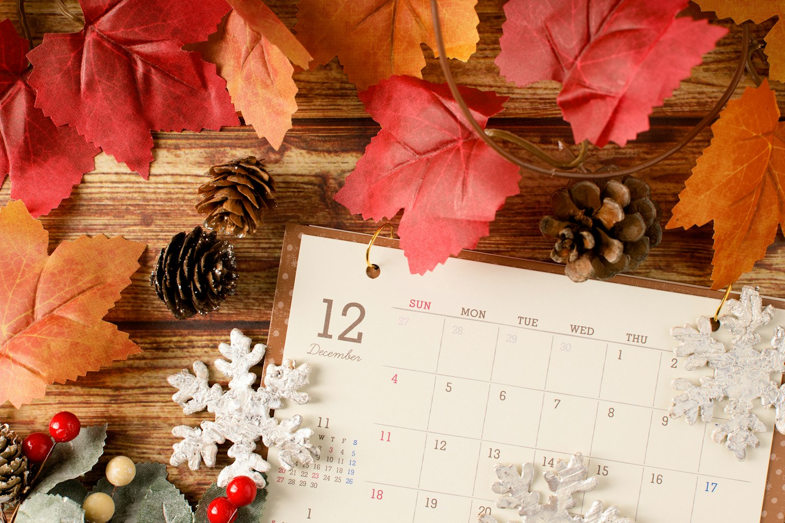 Calendario con hojas de otoño piñas y copos de nieve dispuestos decorativamente