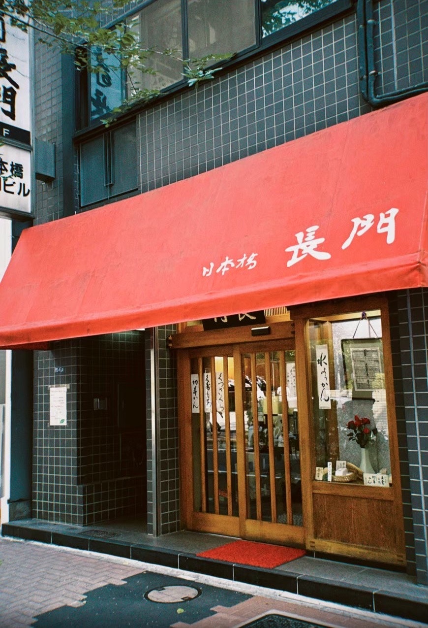 赤い暖簾のある路地の小さな店舗入口