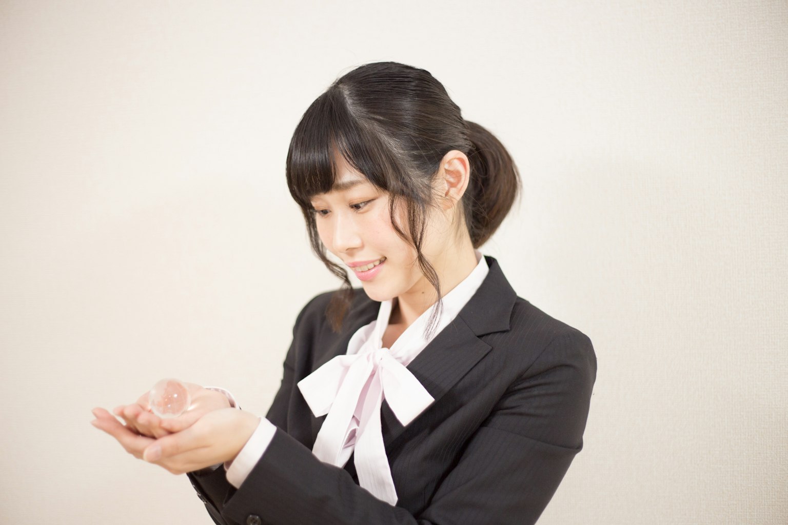 Une femme en costume souriant en tenant ses mains vers le haut