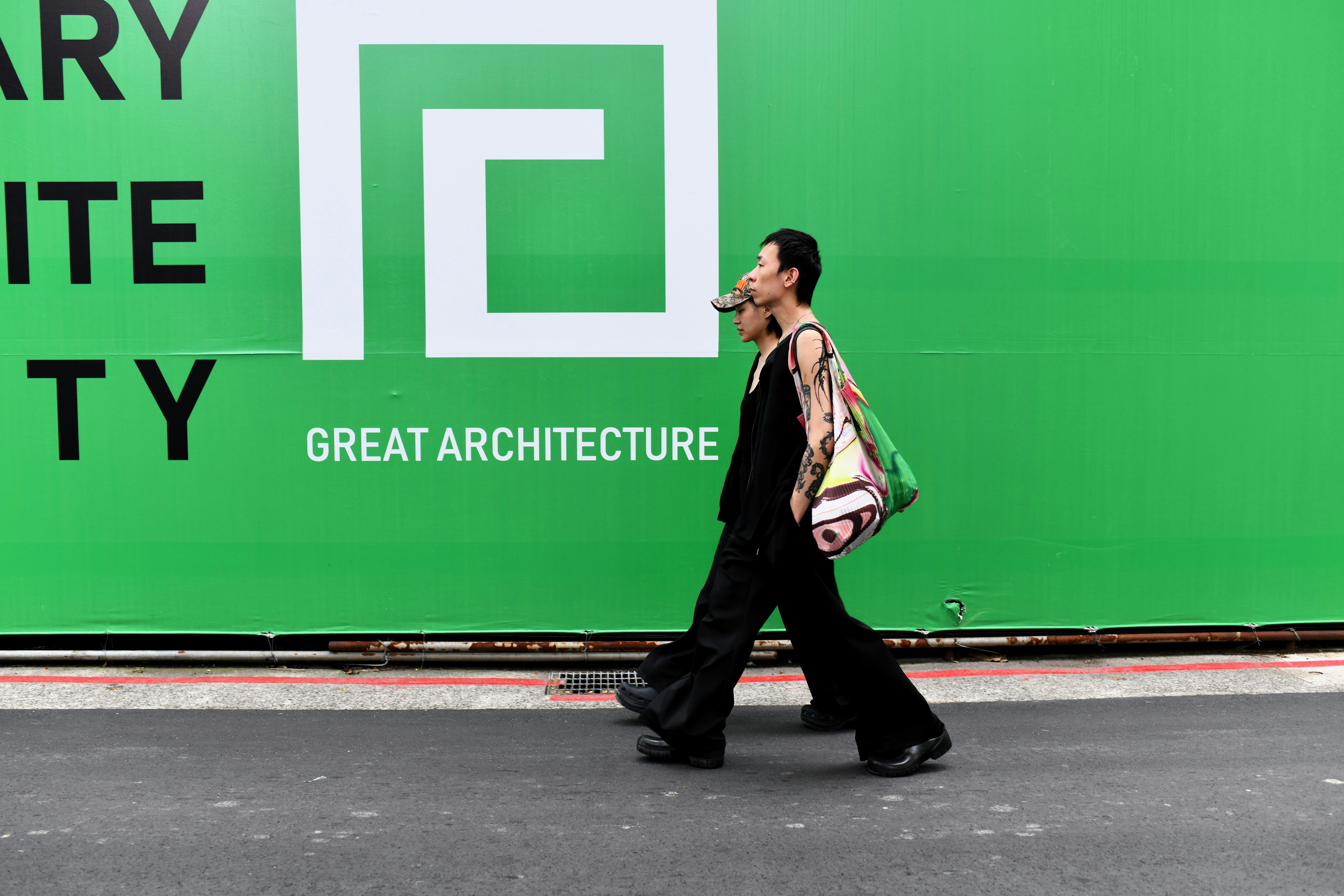 緑の壁面に大きなロゴと「GREAT ARCHITECTURE」がある屋外の街頭風景