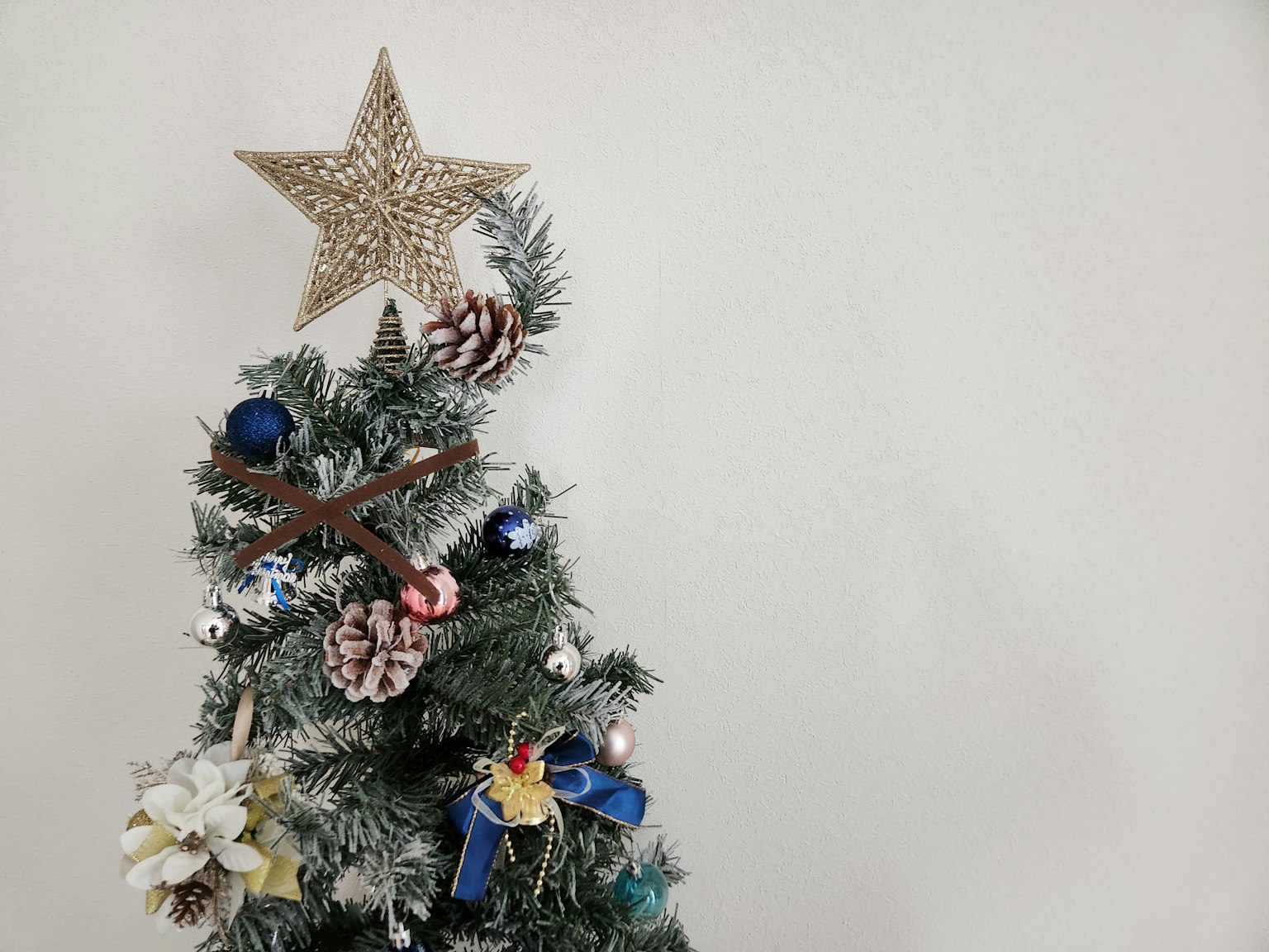 Oben eines dekorierten Weihnachtsbaums mit einem Stern und Tannenzapfen