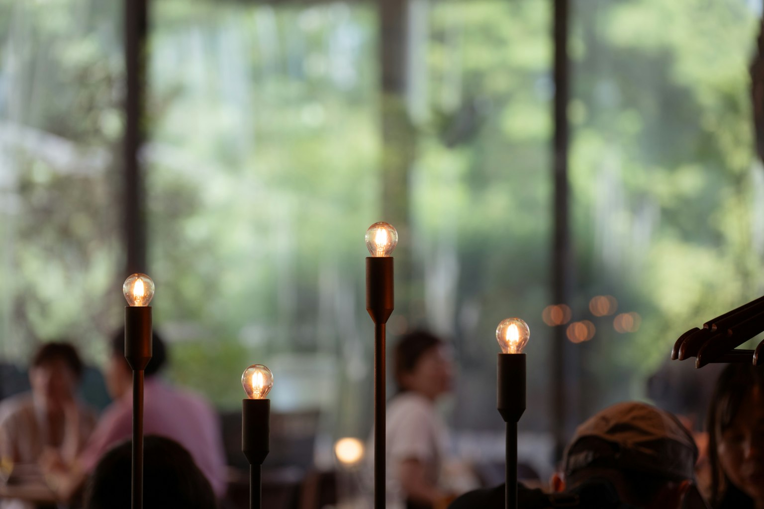Lilin di meja restoran dengan latar belakang hijau yang kabur
