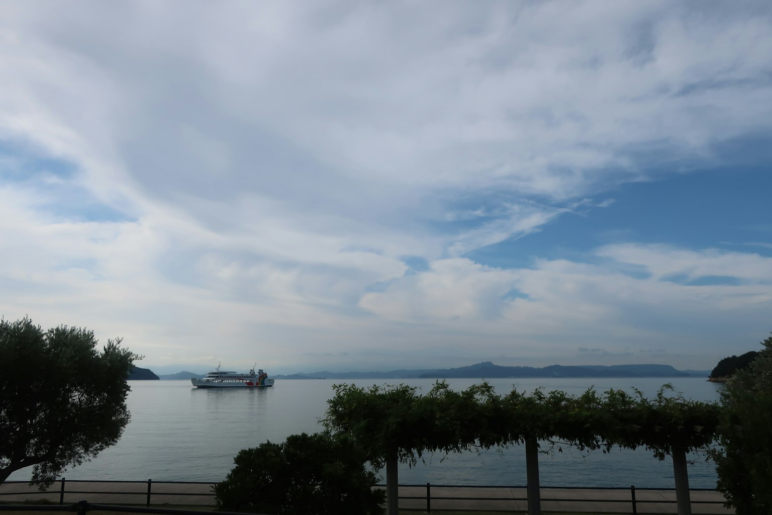 Pemandangan danau yang tenang dengan langit biru dan perahu di kejauhan