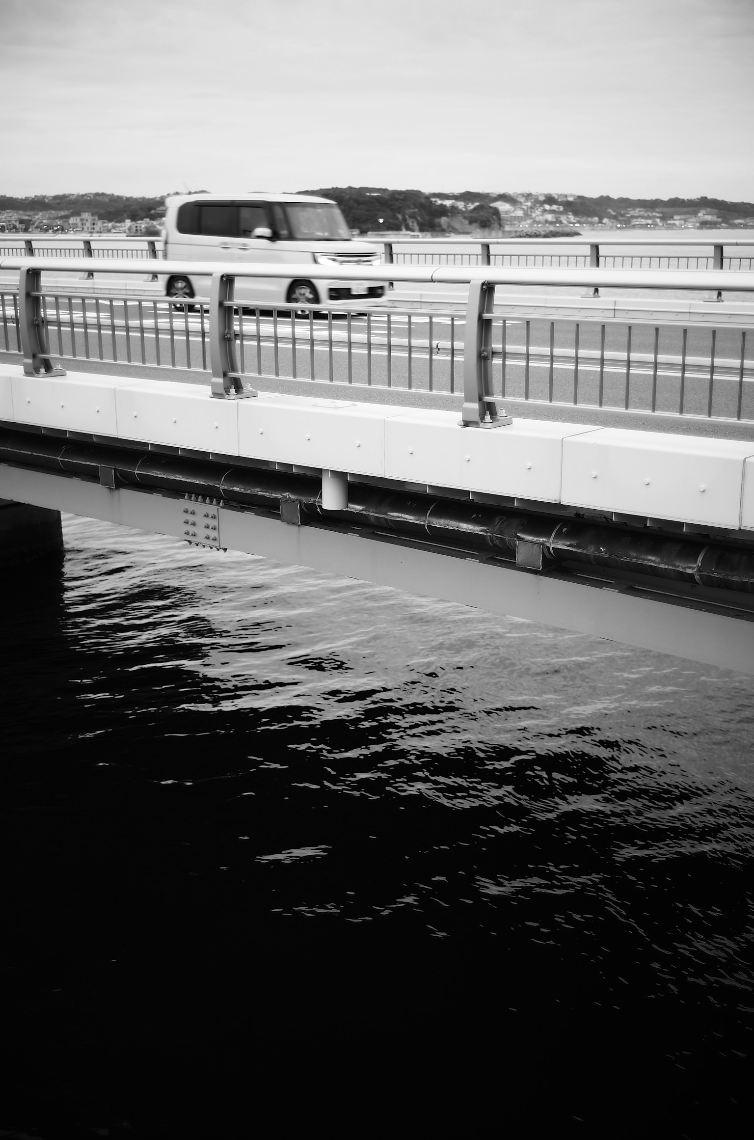 Gambar hitam putih jembatan dengan air mengalir dan mobil