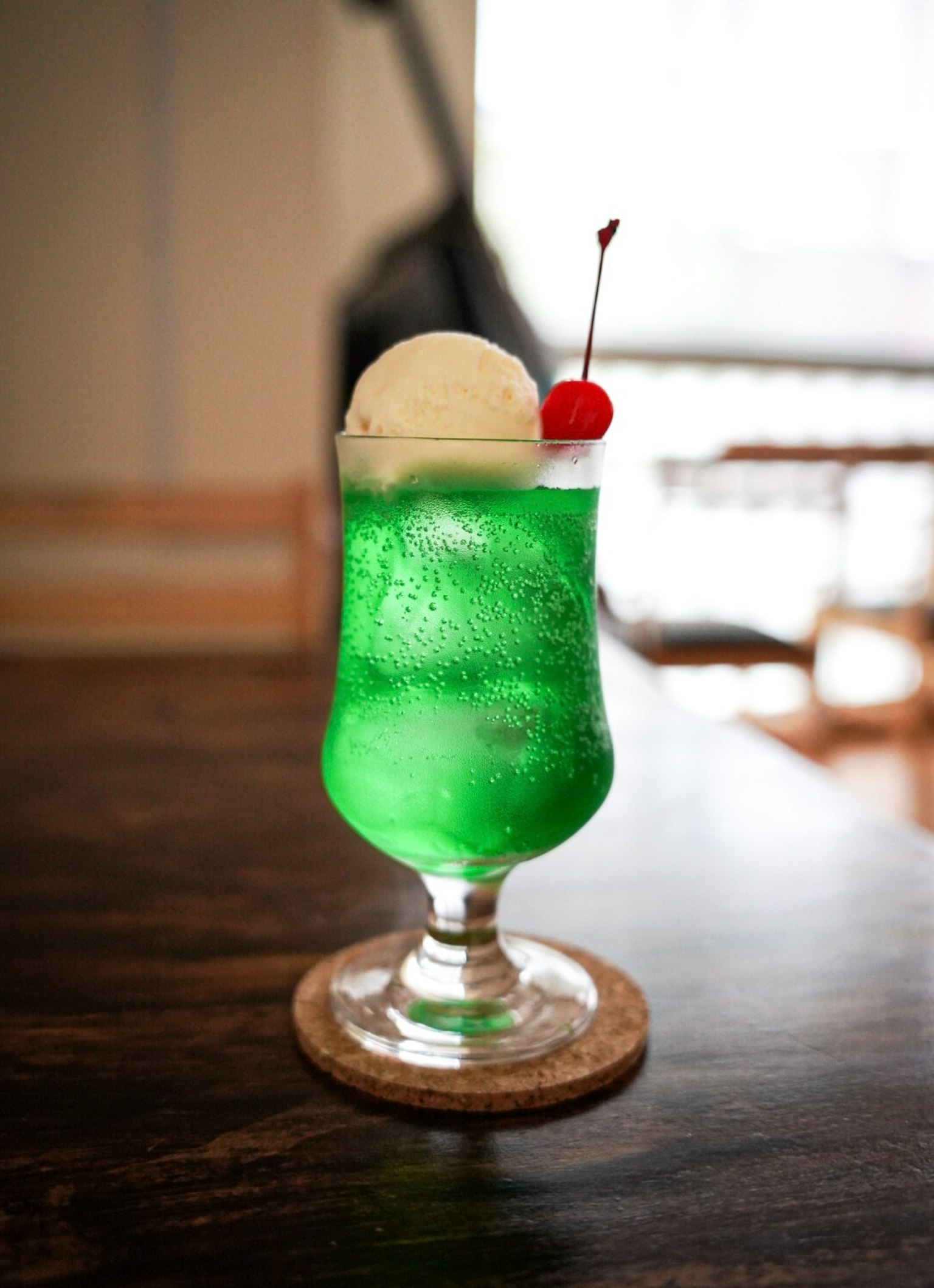 Một ly nước xanh có kem và cherry trên đỉnh