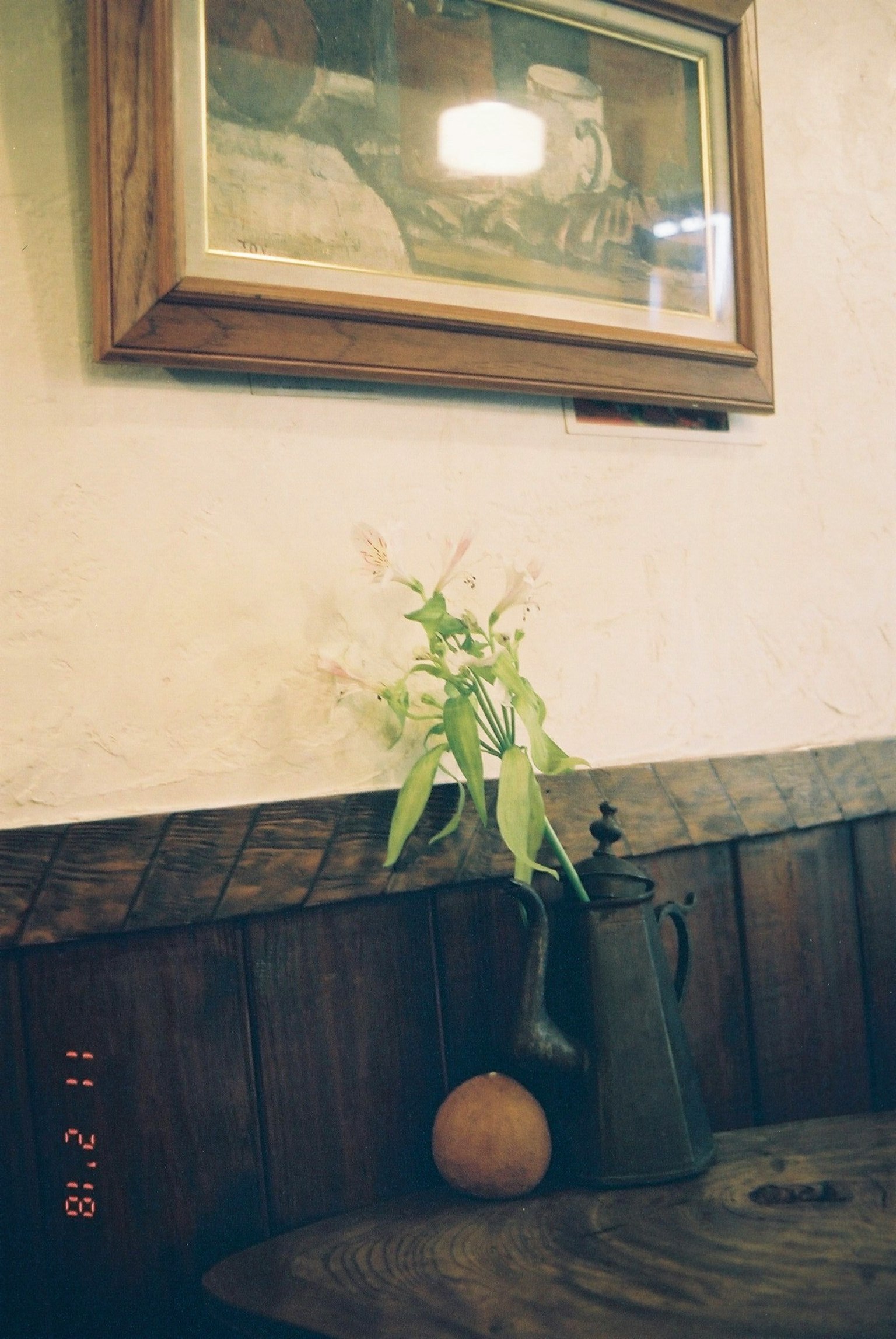 Ein ruhiges Interieur mit einer Vase und Pflanzen auf einem Holztisch