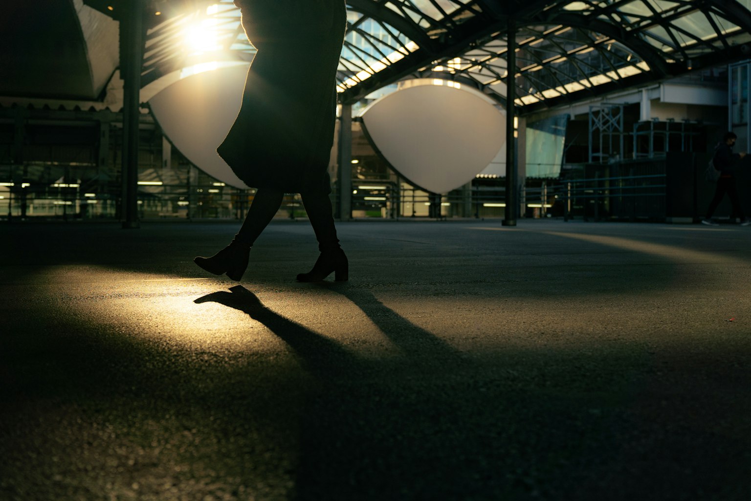 Interior view of a station featuring a woman's legs and striking shadows