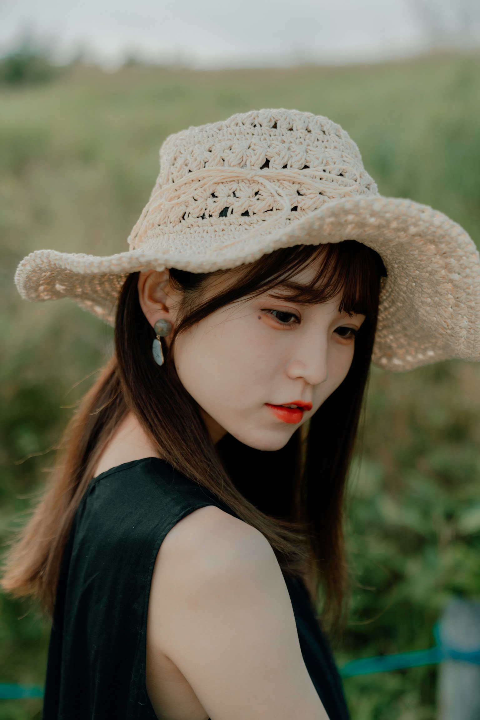 모자를 쓴 여성의 프로필 검은 옷을 입고 자연 배경에서