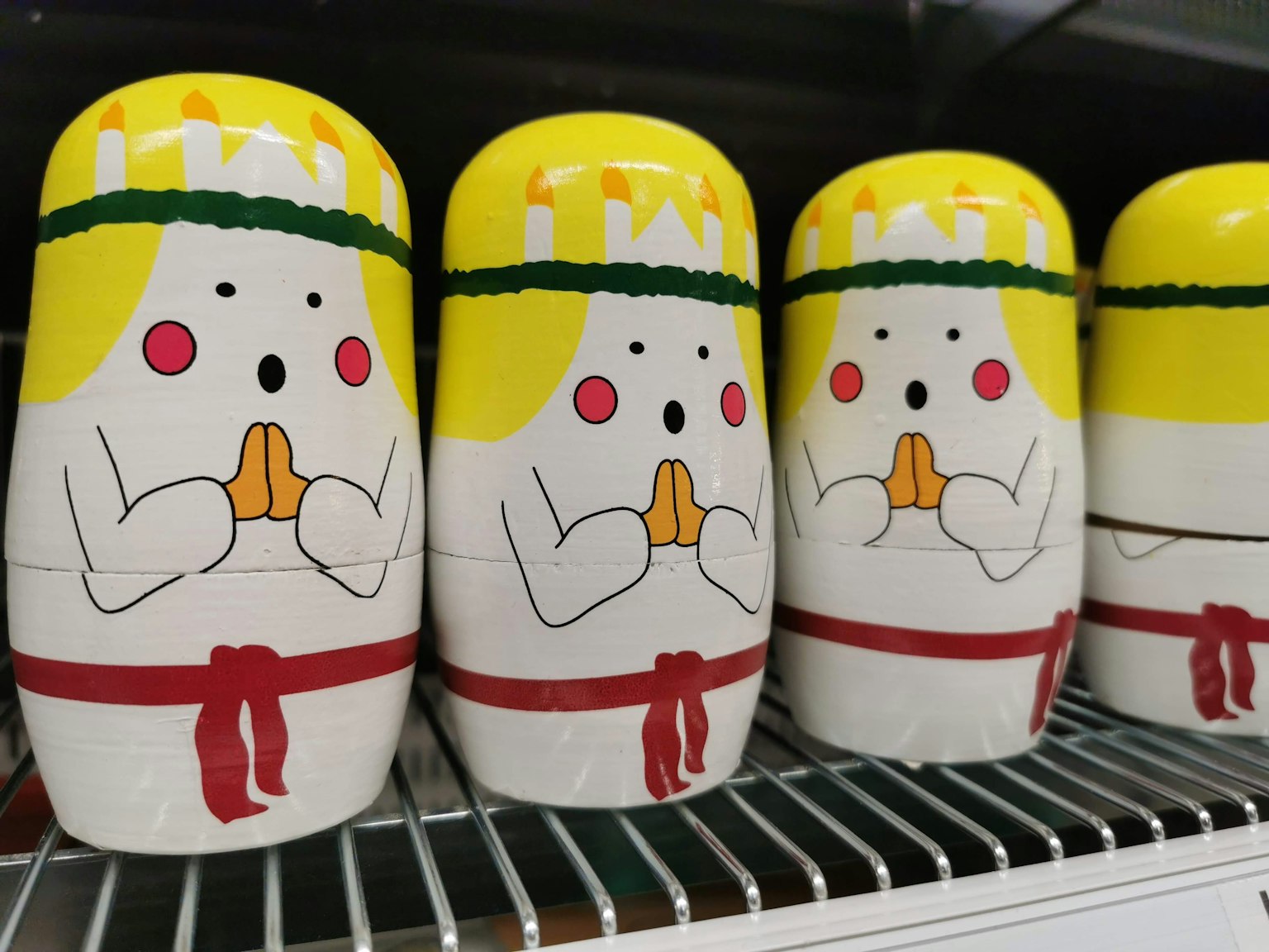 Poupées matryoshka colorées alignées avec des chapeaux jaunes et des ceintures rouges